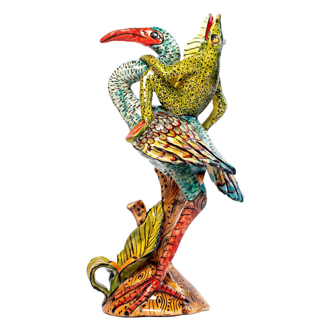 The Ceramic Water Bird Frog Rider, crafted by Zimele Ceramics in South Africa, is a distinctive piece from the African Circus collection. Hand-sculpted by MpIIo and hand-painted by Victor, this sculpture stands 11 inches high and features a