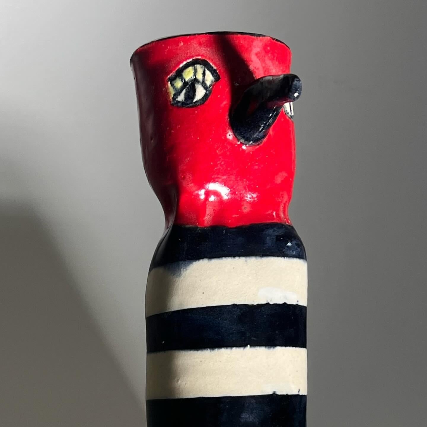 RARE BIRD: a ceramic bird vase with protruding beak, painted face, and striped body, signed by artist, 20th century. Tones of fire hydrant red, eggshell, and licorice. Immaculate. Pick up in LA or we ship worldwide. 
2.5” W x 3.5” D x 8.5” H 