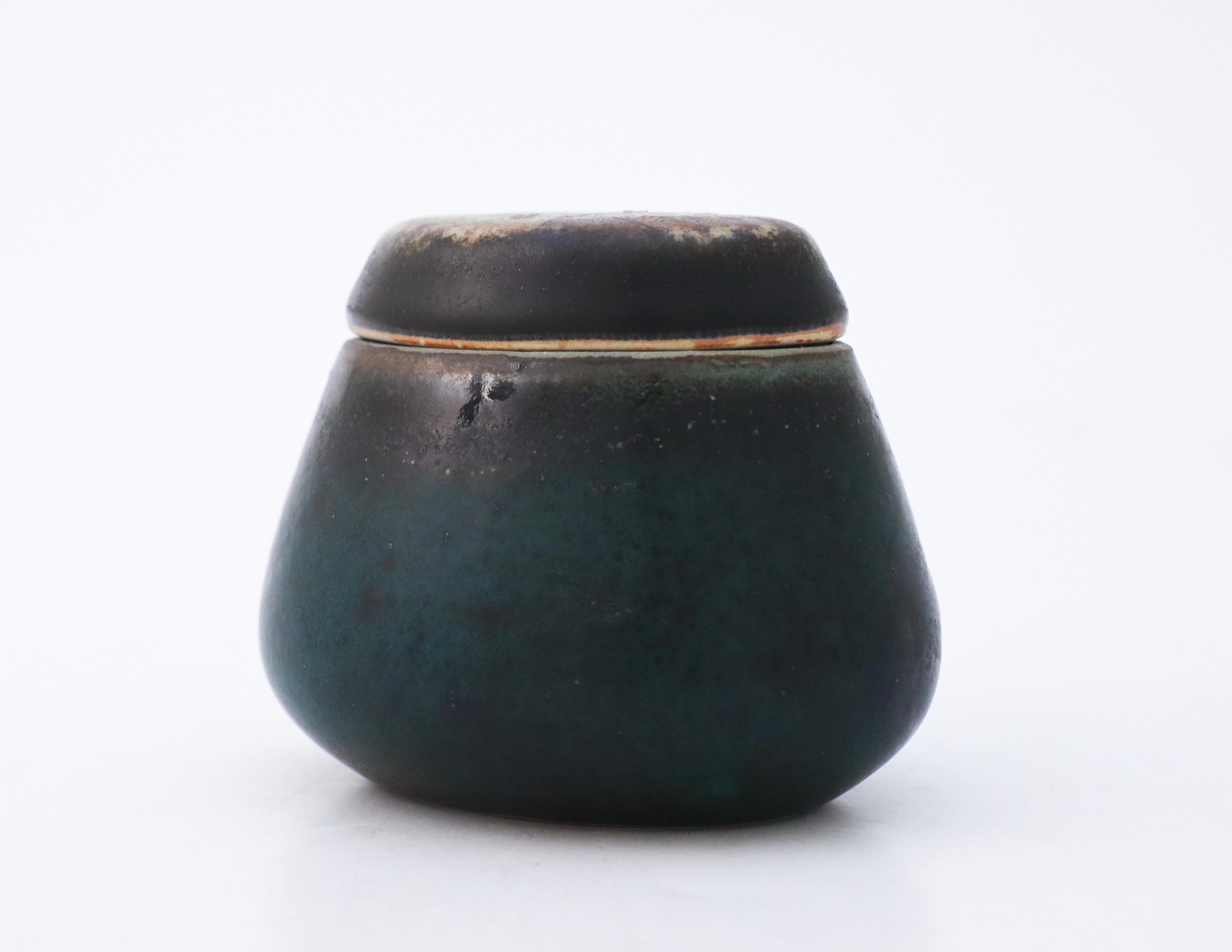 A lidded bowl designed by Carl-Harry Stålhane at Rörstrand Atelier. It is 7.5 cm (3