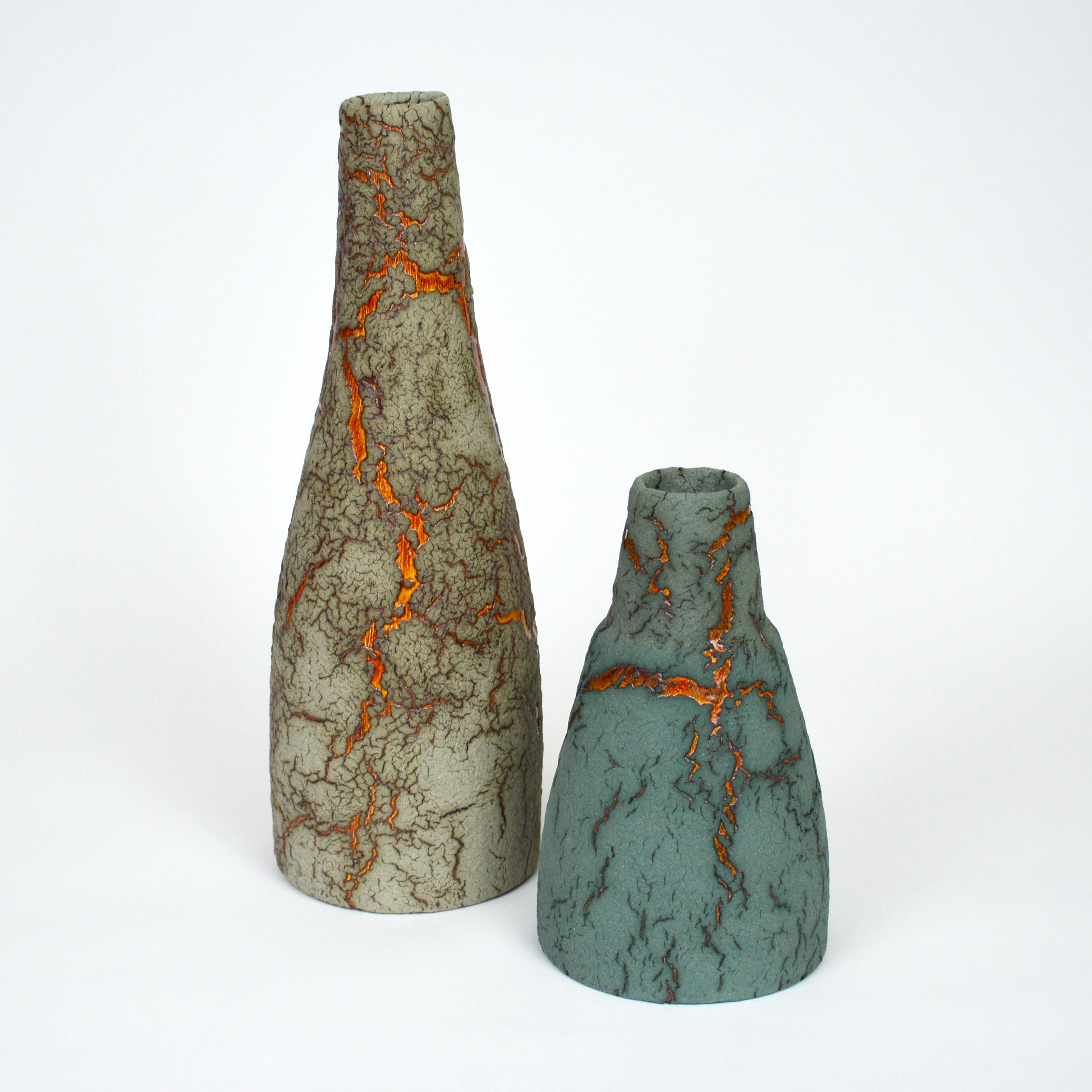 Ceramic bottles by William Edwards.
Hand built earthenware vessels, fired multiple times to achieve a textured surface of random abstraction, sage green matte with amber gloss microcrystalline glaze breaking through that sparkles in certain
