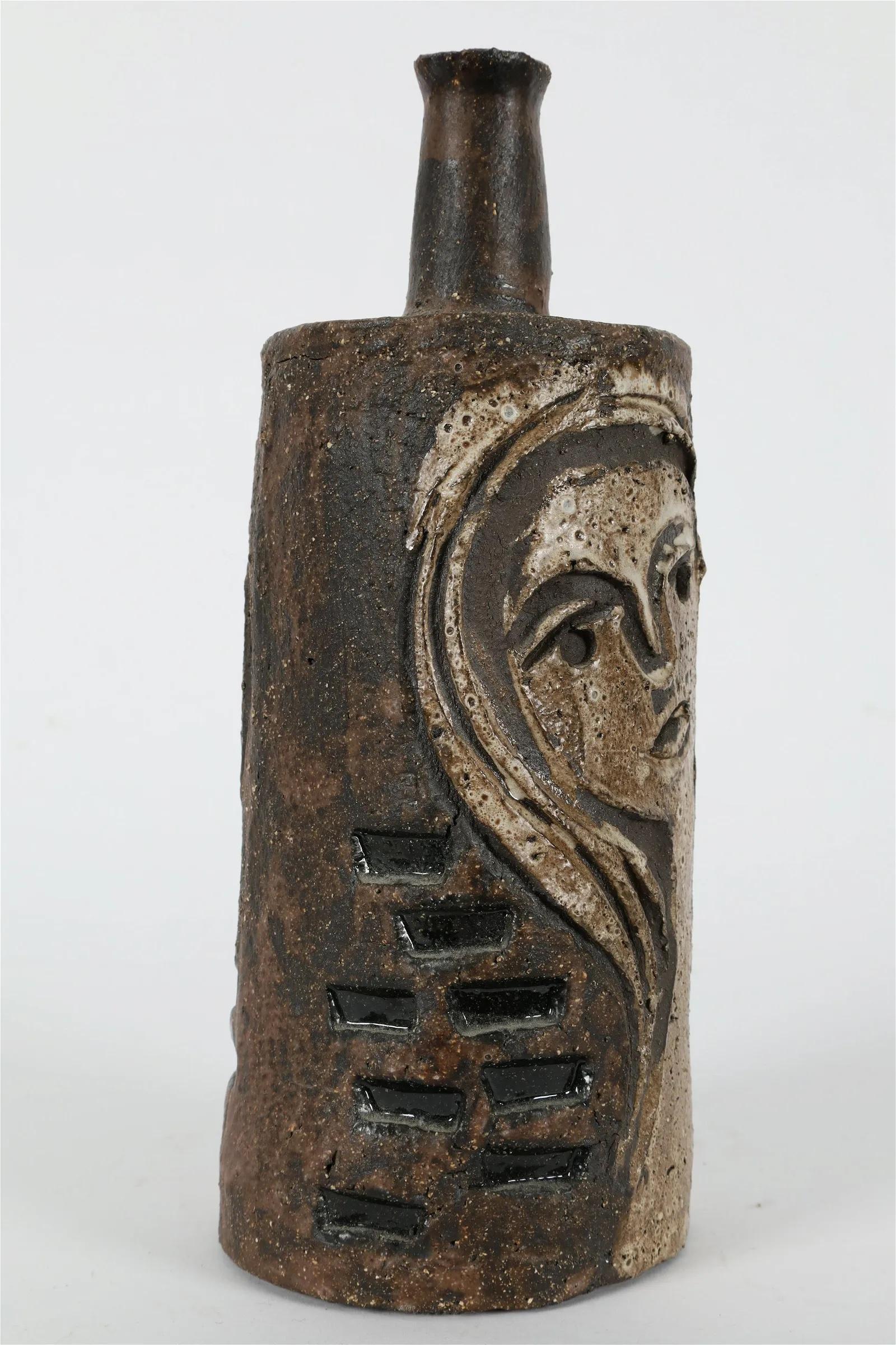 Vase en céramique en forme de bouteille avec des visages gravés par Charles Sucsan.