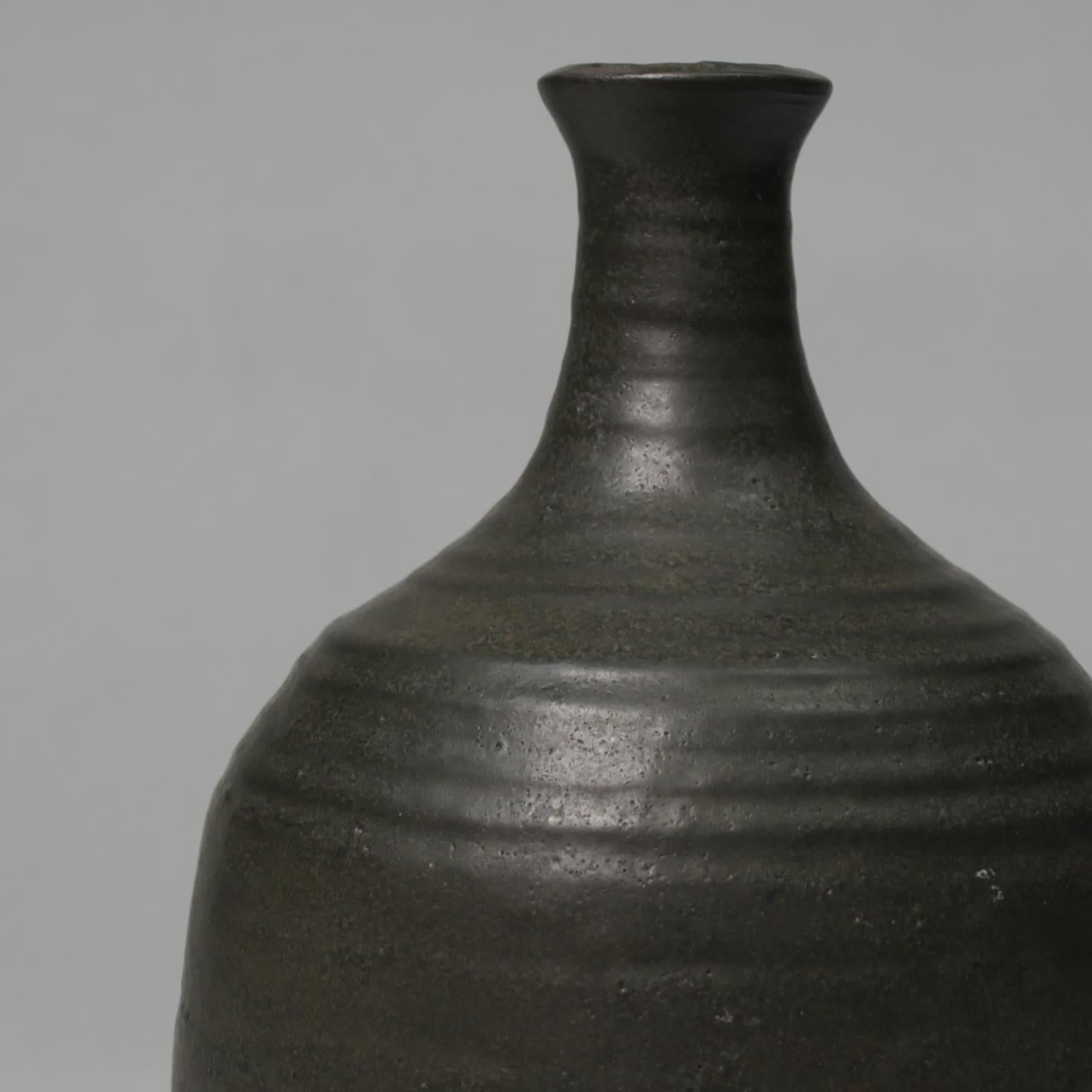 An exquisite hand-thrown ceramic vase with speckled dark green over glaze and a prominent black matte underglaze from the Dutch potter Guy van Hardenbroek. This piece was previously in the national collection of Rijks Verspreide Kunstvoorwerpen.