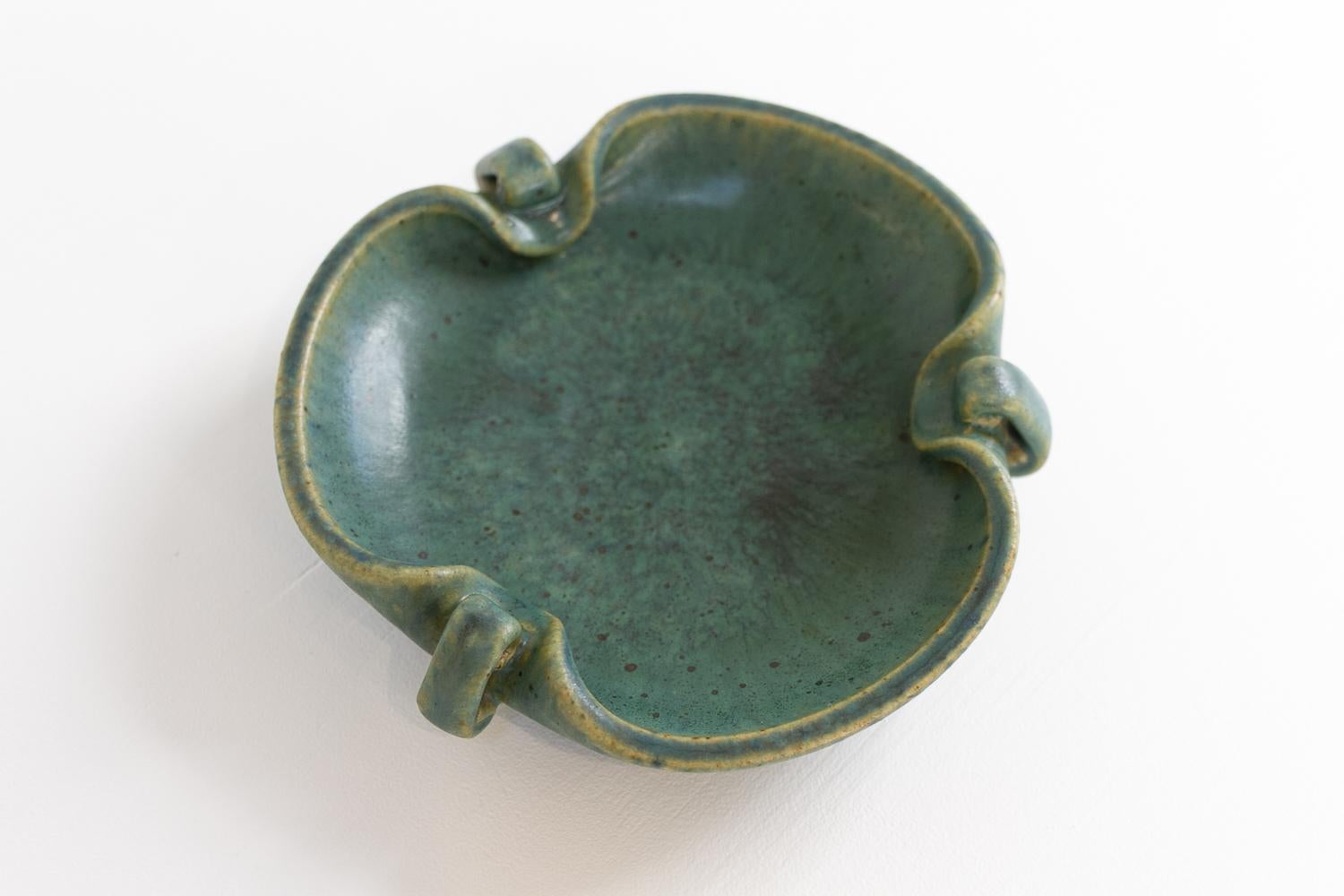 Ceramic bowl by Arne Bang, 1940s.
Danish organically shaped glazed ceramic bowl or ashtray by Arne Bang, Denmark made in the 1940s. Beautiful speckled glaze in green and earth shades. 

Diameter: 17 cm, height 3.5 cm.
Signed underneath with monogram
