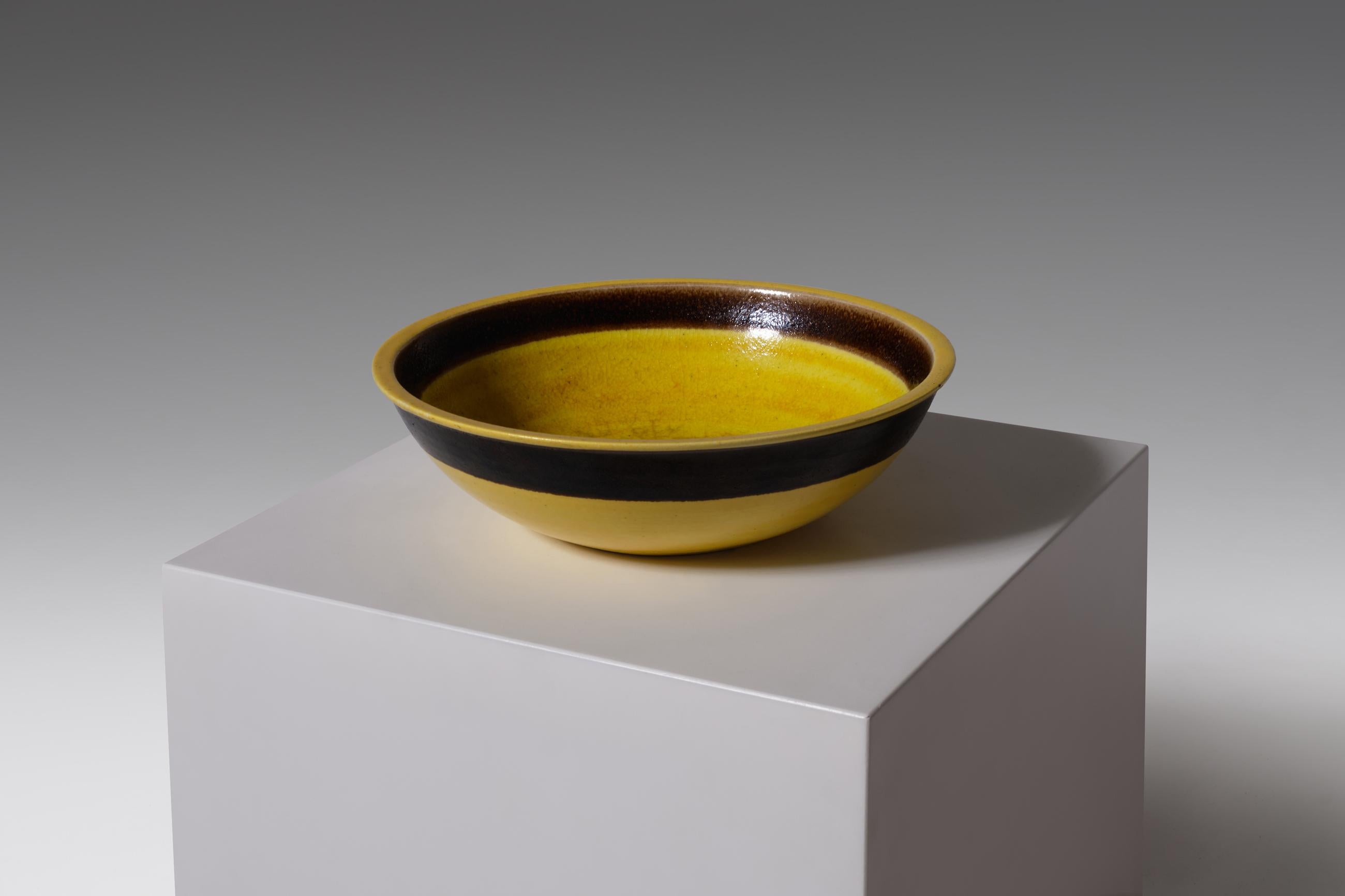 Rare large bowl by Bruno Gambone, Italy, 1970. Outstanding large object in a fantastic bright yellow glaze with a dark brown / aubergine line on the in- and outside. A beautiful crackle pattern is visible inside the bowl, beautiful warm texture. In