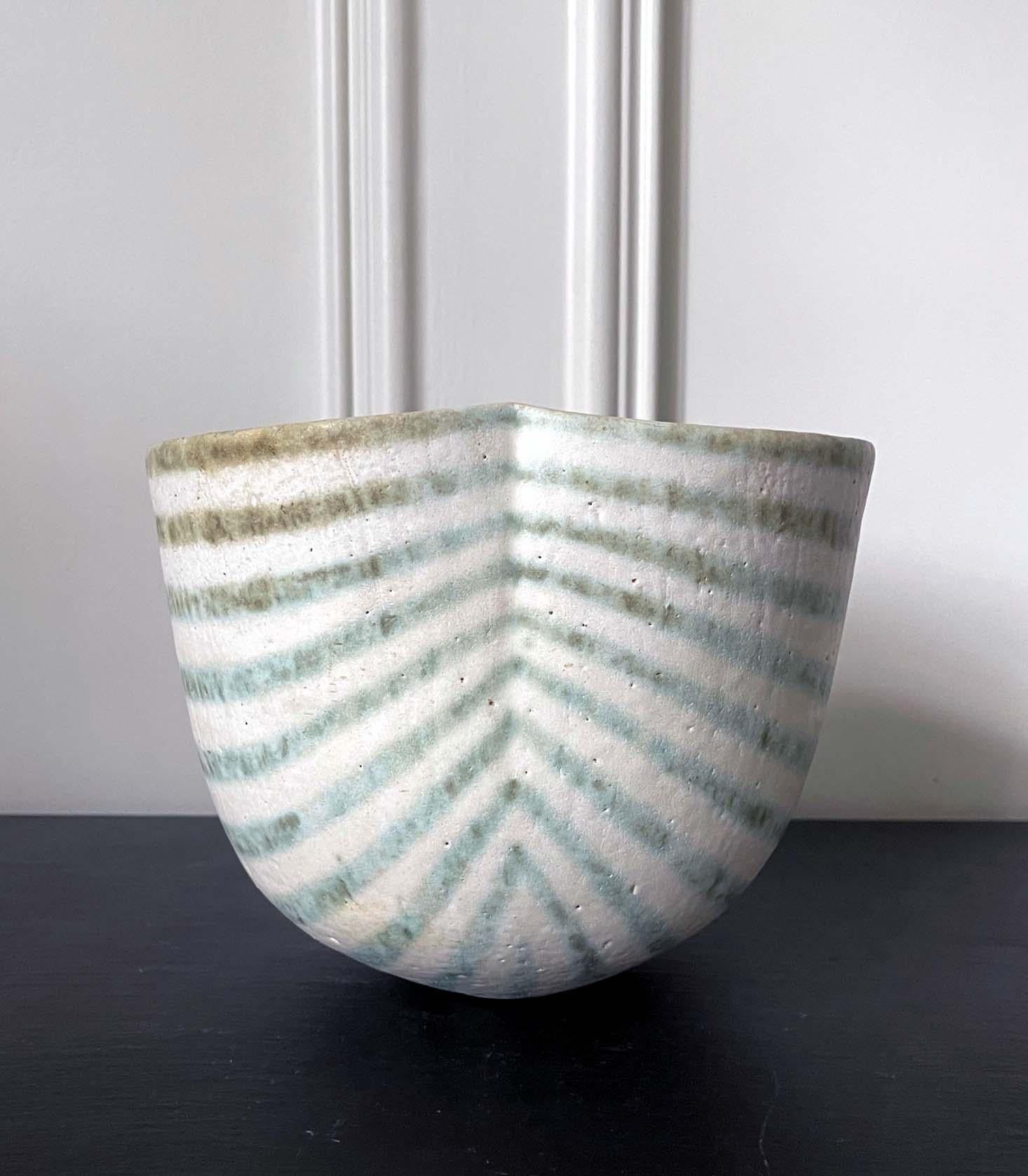 Vase en grès à décor de bandes émaillées et rayées du céramiste de studio britannique John Ward (1938-2023), vers 1986. Le récipient prend sa forme simple mais distincte entre un bol profond et un vase, avec son pliage organique et sa courbe douce.
