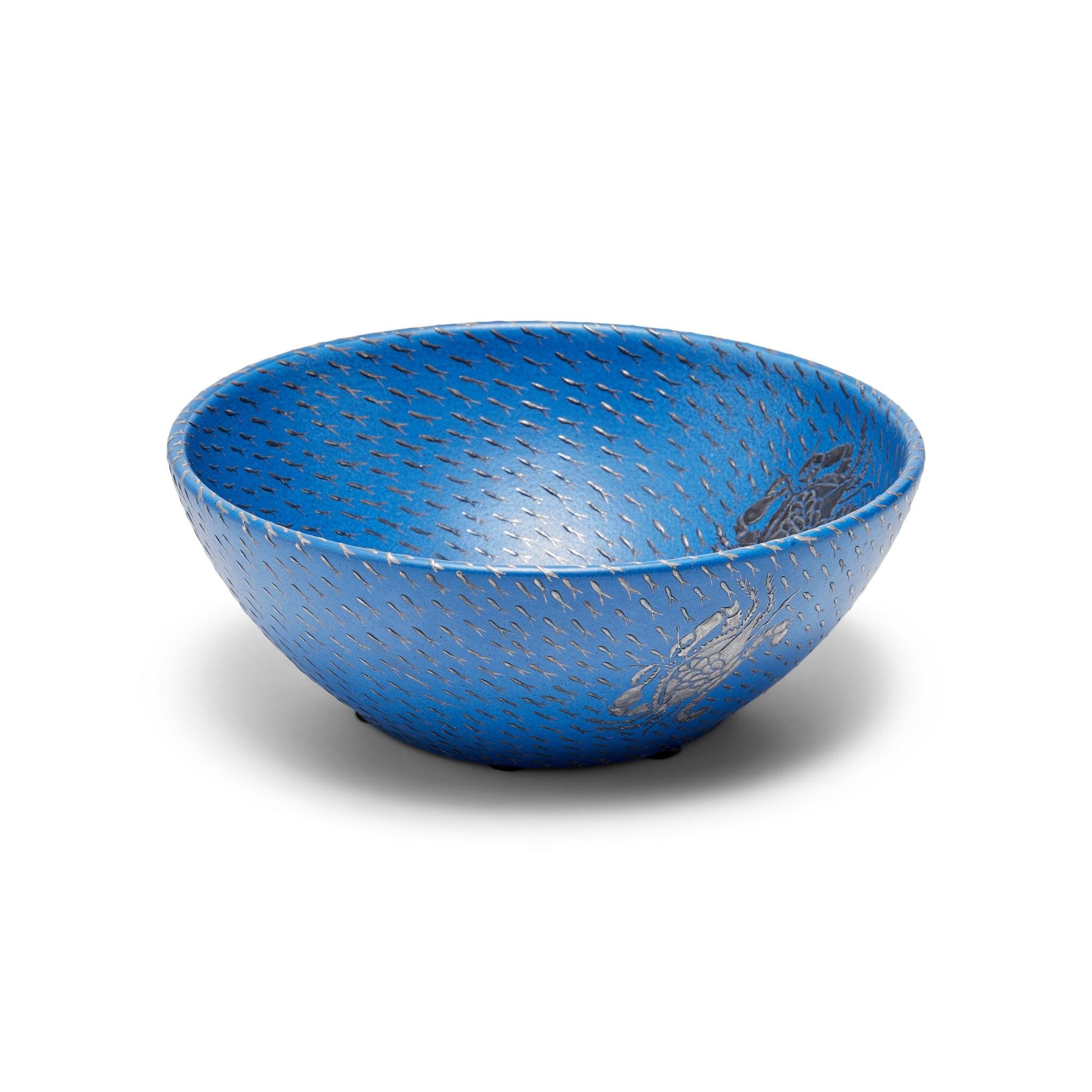 A blue ceramic bowl with silver overlaid crabs and petite fish.