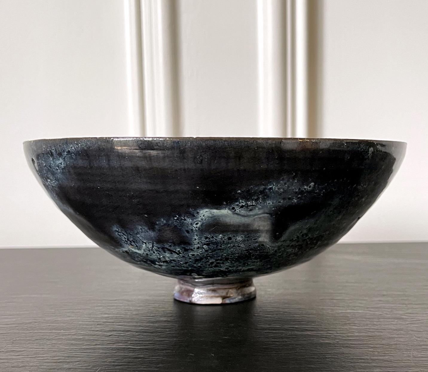 A ceramic bowl by American artist and studio potter Beatrice Wood (1893-1998). The elegant bowl has a deep half-hemisphere form that is supported by a short and small foot ring. The wall was rather thinly potted, a little unusual for the artist. The