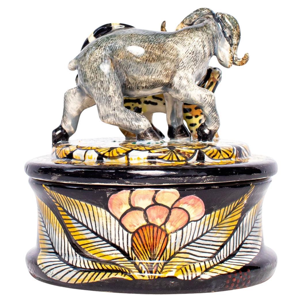 The Buffalo & genet cat jewelry box from Senzo Duma Ceramics is a testament to South African artistry. Hand-sculpted by Thabiso and hand-painted by Nqoh, it measures 5 inches in height, 4 inches in length, and 4 inches in width. This exquisite piece