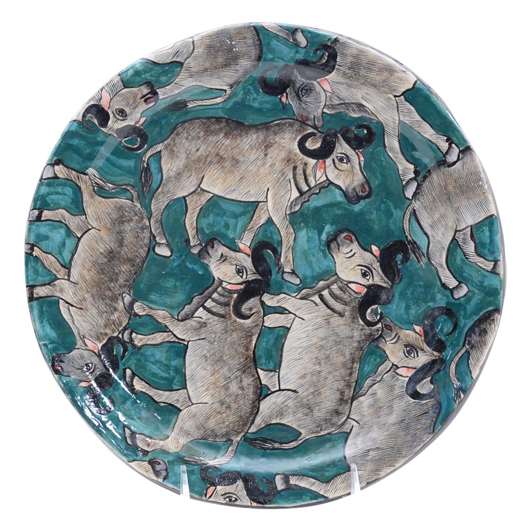 Voici la Buffalo Plate, une étonnante œuvre d'art en céramique méticuleusement peinte à la main par Nompilo Zaba et sculptée à la main par Victor Shabalala à Zimele Ceramics en Afrique du Sud. Mesurant 1 pouce de haut, 11 pouces de long et 11 pouces