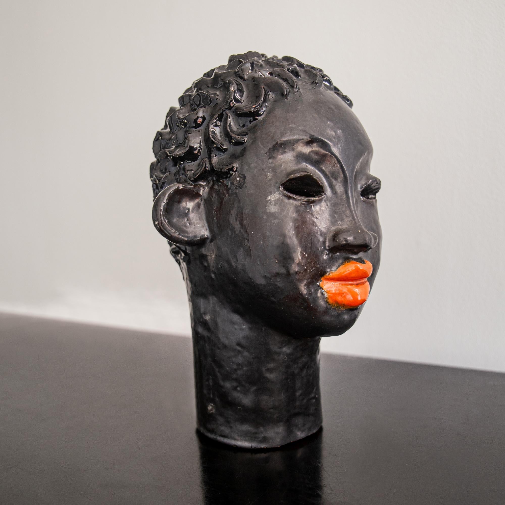 A rare Wiener Werkstätte ceramic, beautifully stylised as the head of a young African woman with flame orange lips. Overall in a black glaze, with enigmatic tilt to the composition and wonderfully textured curls.

The Wiener Werkstätte, established