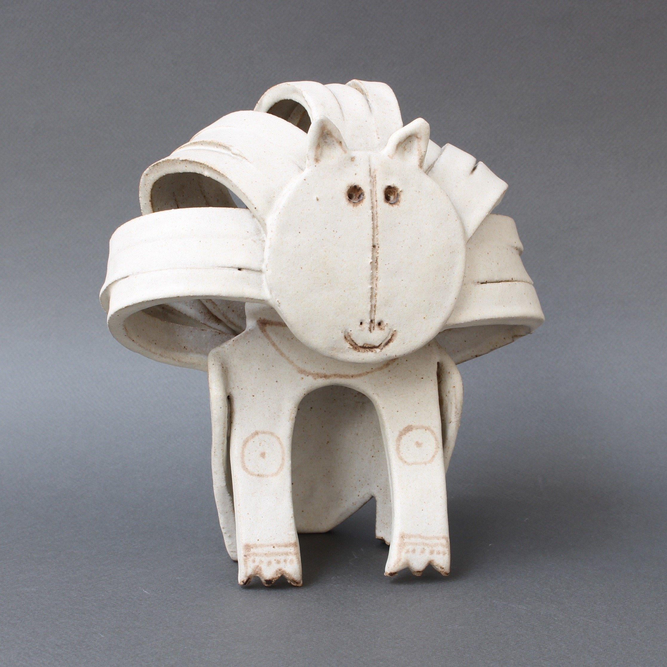 Ceramic cat or lion sculpture by ceramicist Bruno Gambone, circa 1970s. This enchanting seated cat sculpture is truly a work of art. It is whimsical, yet beautiful in its use of the pared-down design elements associated with minimalism. Its