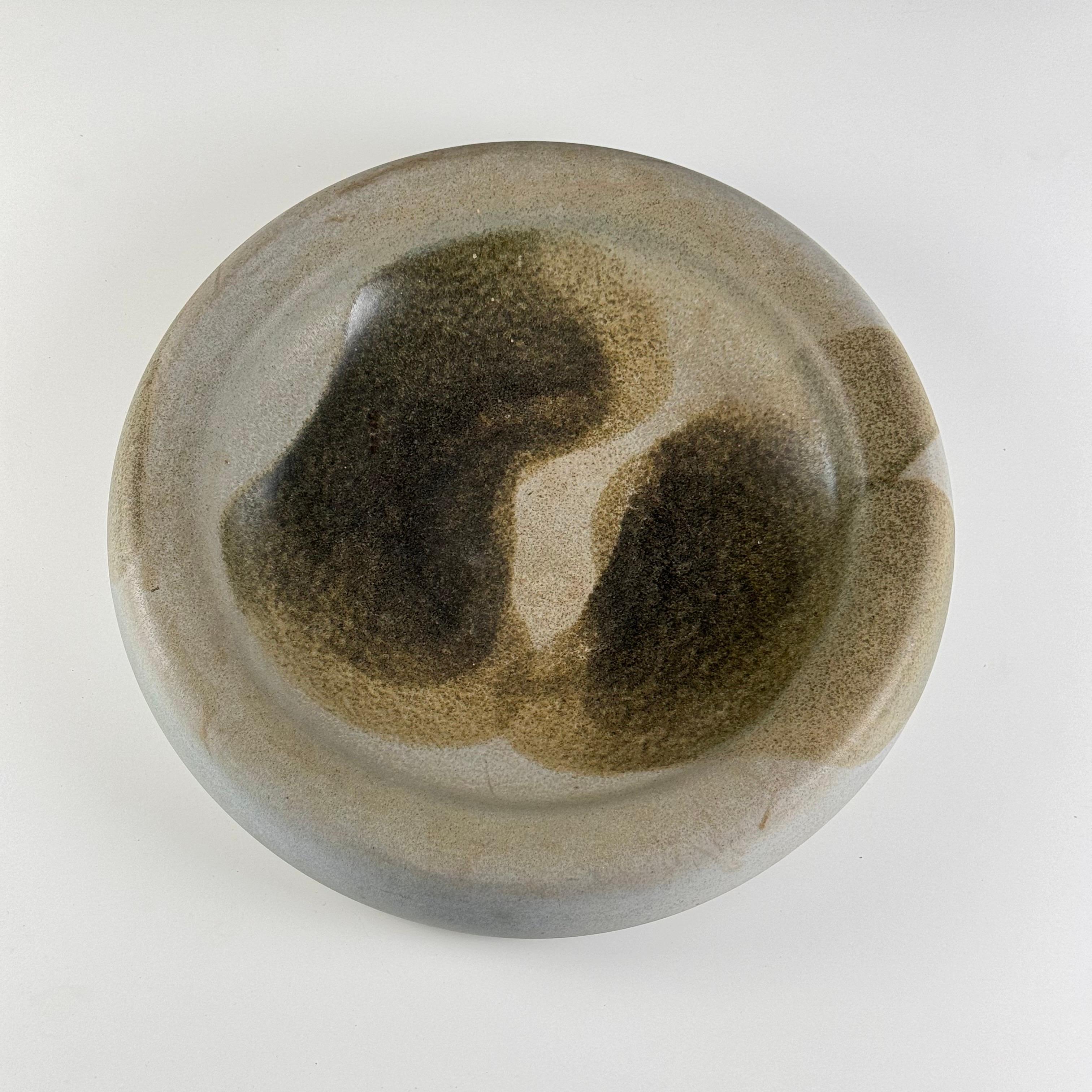 
Presentamos un gran e impresionante centro de mesa de cerámica diseñado por Franco Bucci para el Laboratorio Pesaro en la década de 1970. Esta exquisita pieza mide 45 cm de diámetro y 4,5 cm de altura, lo que la convierte en un complemento