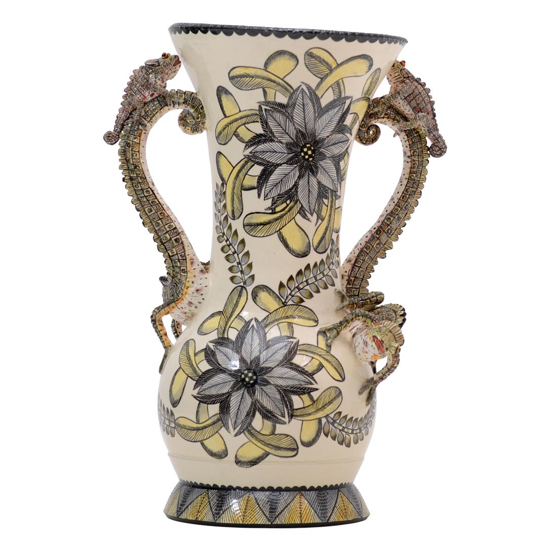El Jarrón Camaleón de Love Art Ceramic es un testimonio del rico patrimonio artístico de Sudáfrica Esculpido a mano por Sabelo Ntshalintshali y meticulosamente pintado a mano por Winnie Nene, esta obra maestra de cerámica mide 13 pulgadas de alto,