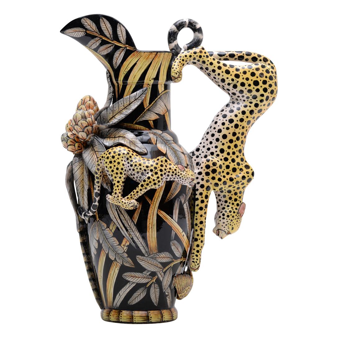 Imvelo Natural Art presents a striking ceramic Cheetah Jug, meticulously crafted in South Africa. Hand-sculpted by Bennett Zondo and adorned with intricate hand-painted details by Elvis Mkhize, this jug stands 11 inches high, 14 inches long, and 8