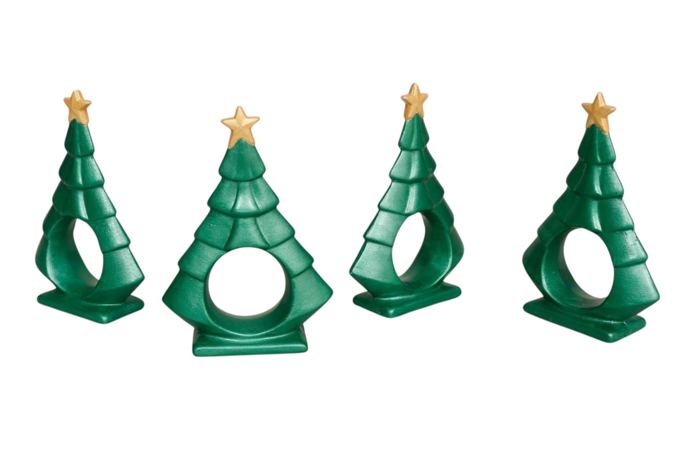 Un ensemble de quatre ronds de serviette en céramique en forme d'arbre de Noël. Peint à la main dans un vert mat satiné surmonté d'étoiles dorées. Dimensions par rond de serviette.