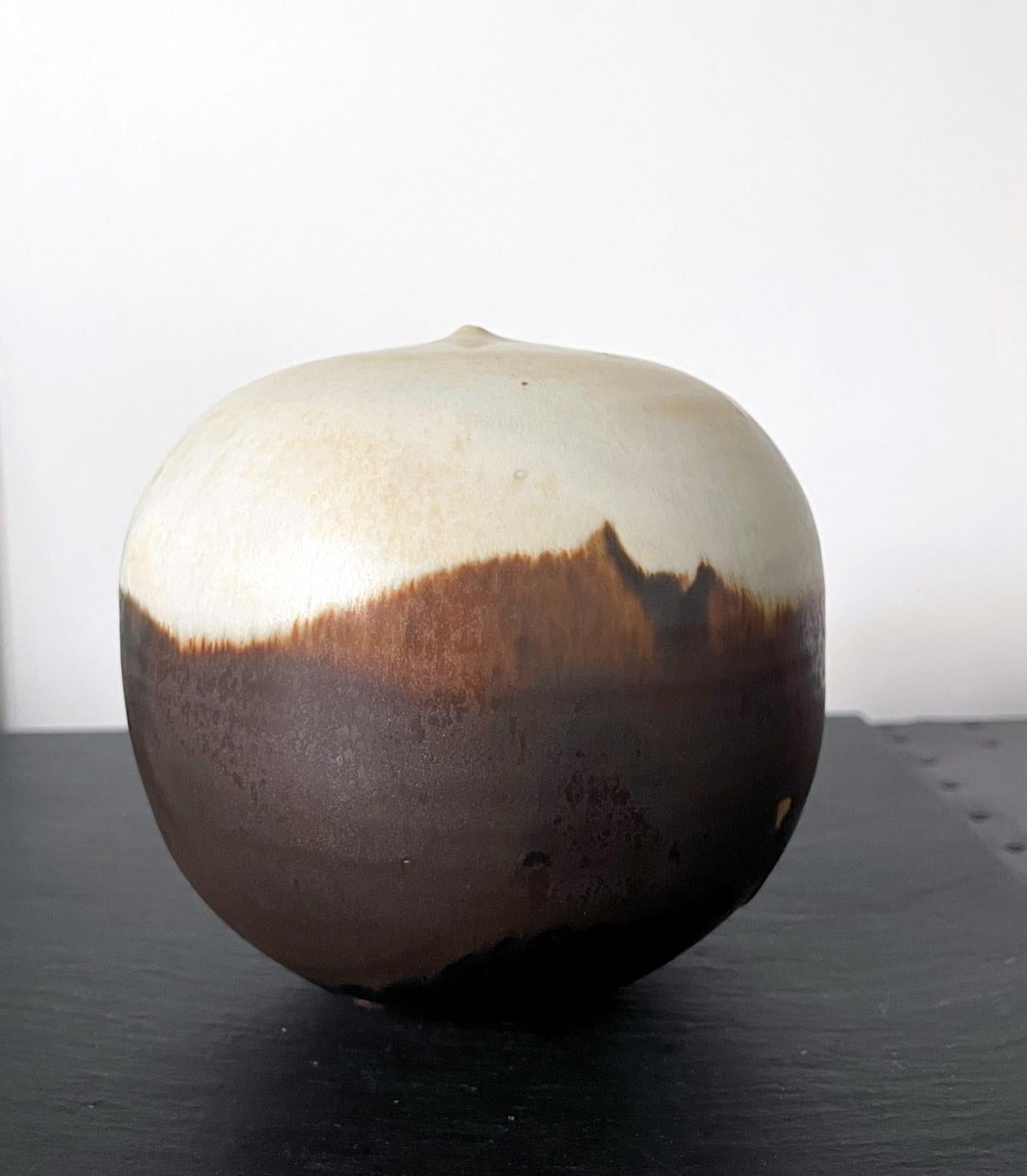 A ceramic closed-form pot by Japanese American artist Toshiko Takaezu (American, 1922 - 2011). This iconic form by the artist takes the simplest organic form but is instilled with a deeper philosophy. The void space and the air trapped inside of the