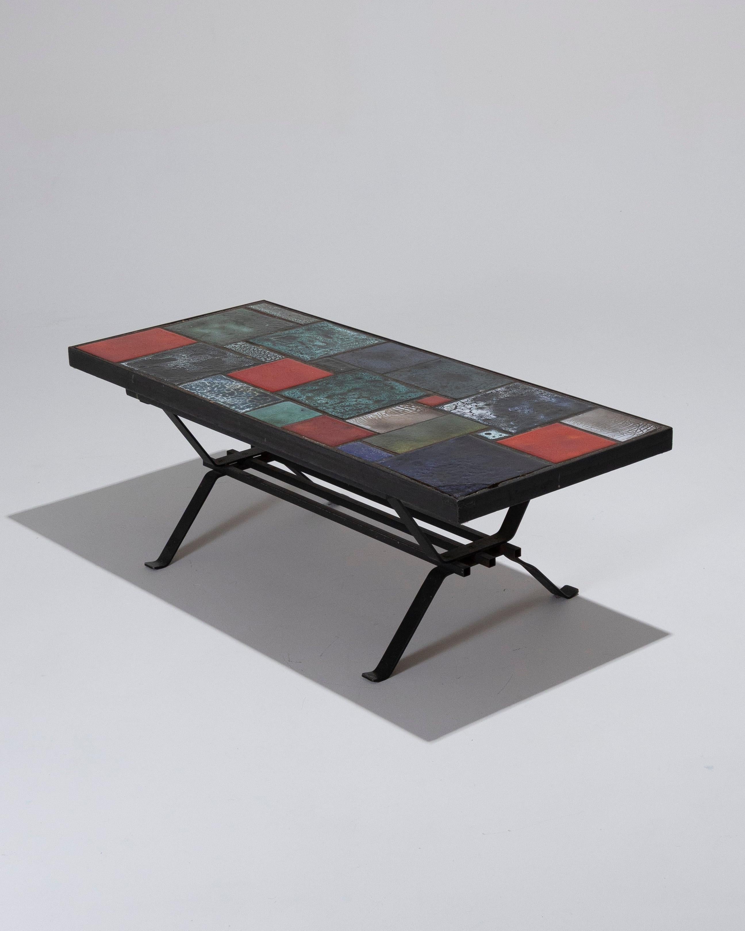 Table basse en céramique des années 1960. Le plateau est constitué de carreaux de céramique émaillée présentant des motifs abstraits colorés. Structure en métal noir avec des pieds évasés et une étagère inférieure grillagée.
Très bon état - une