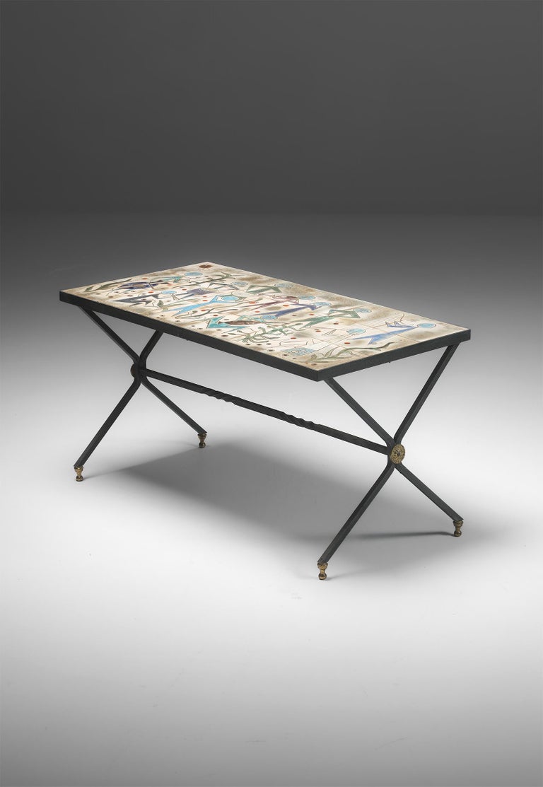 Decorative metal coffee table decorated with a ceramic of Charles Emile Pinson. It shows a playful scenery with an orchestra playing music underwater surrounded by fish and coral, signed Concert Marin. As a ceramist, painter and etcher, Pinson has a