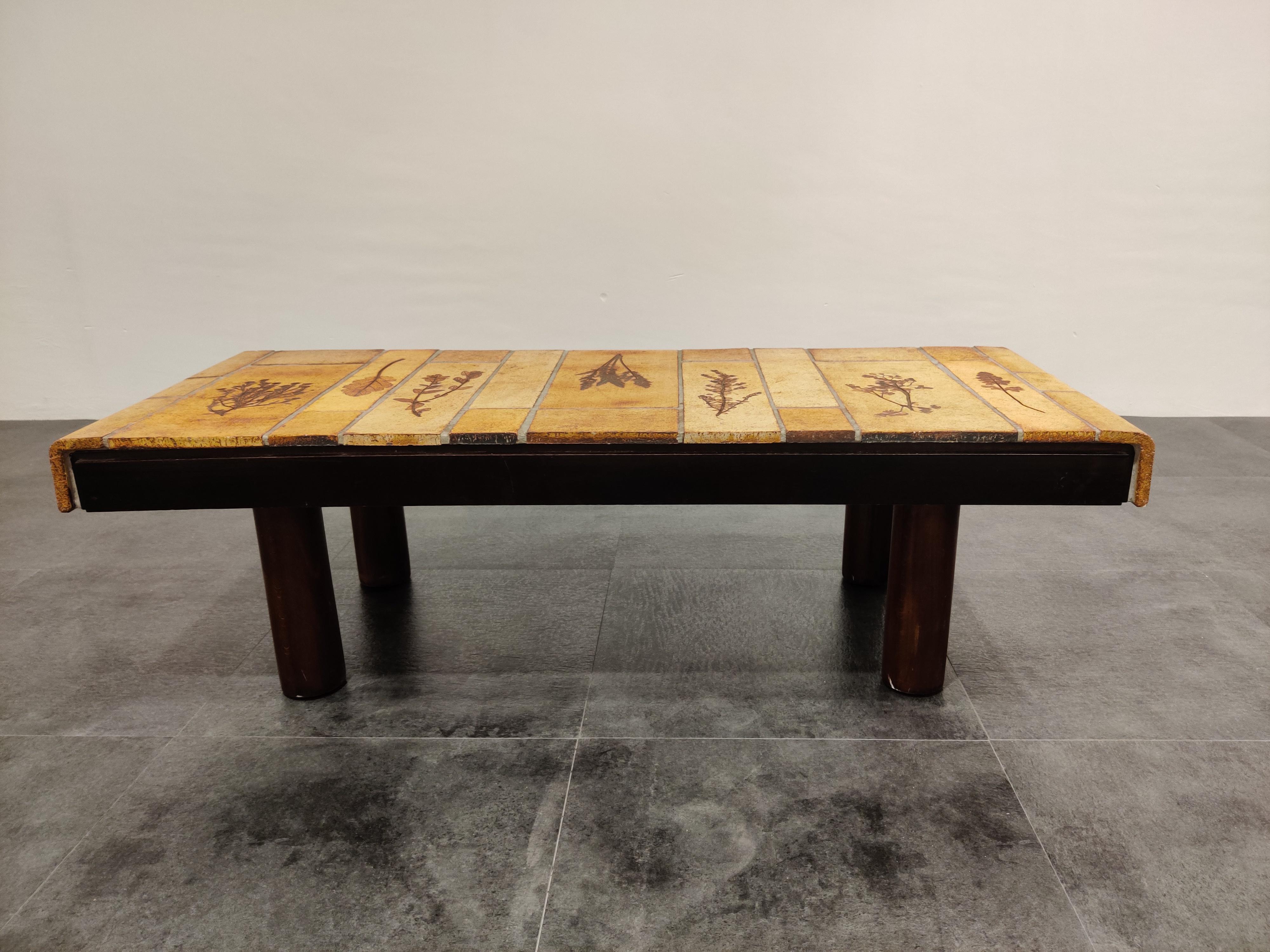 Vintage wooden coffee table made by Roger Capron (1922-2006) featuring an earthenware ceramic top with natural motives.

Round wooden legs.

Signed Roger Capron

Minimal chip on one of the corners.

1970s - France

Dimensions:
Length
