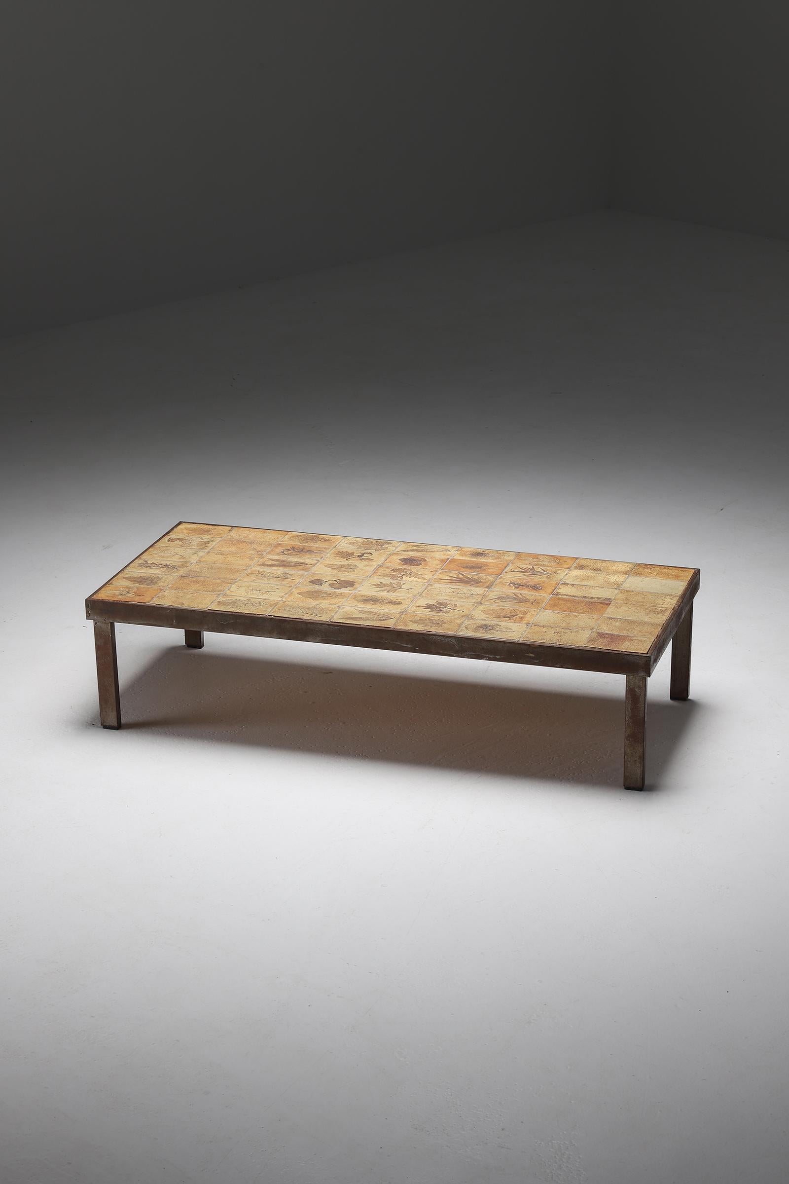 Table basse rectangulaire Garrigue de Roger Capron datant des années 1960, Vallauris, France. La table a une structure et des pieds en métal et un plateau en céramique avec des motifs d'herbier incrustés. Les carreaux artisanaux sont fabriqués selon