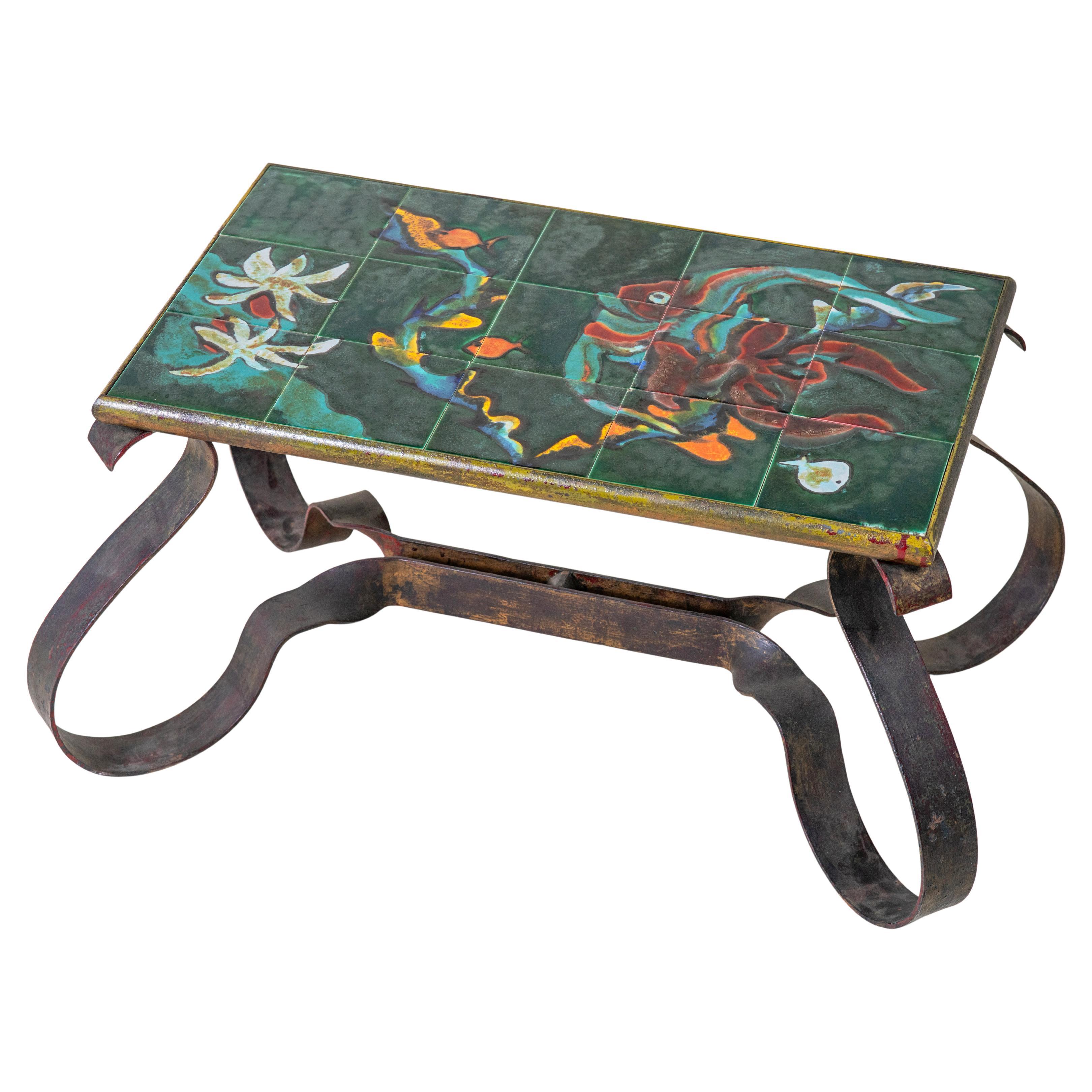 This striking vintage coffee table from the South of France, circa 1950, is a rare example of craftsmanship that blends artistry with functionality. The tabletop is composed of hand-painted ceramic tiles, each richly detailed with a whimsical