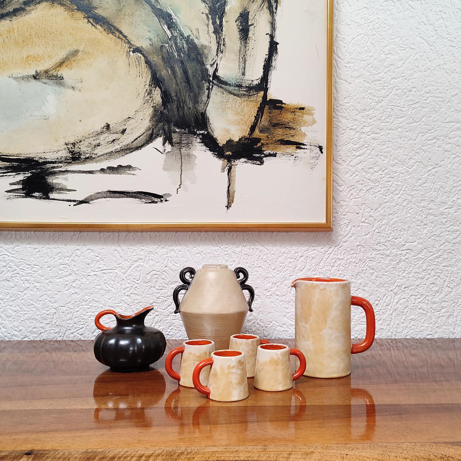 Early modernist stoneware vessels designed by Anna-Lisa Thomson, for Upsala-Ekeby, Sweden, 1930s.
Comprising:
1 - a pitcher and four mugs in marbleized yellow outer glaze, with inside and handles glazed in orange glaze.
2 - a gorgeous dark brown