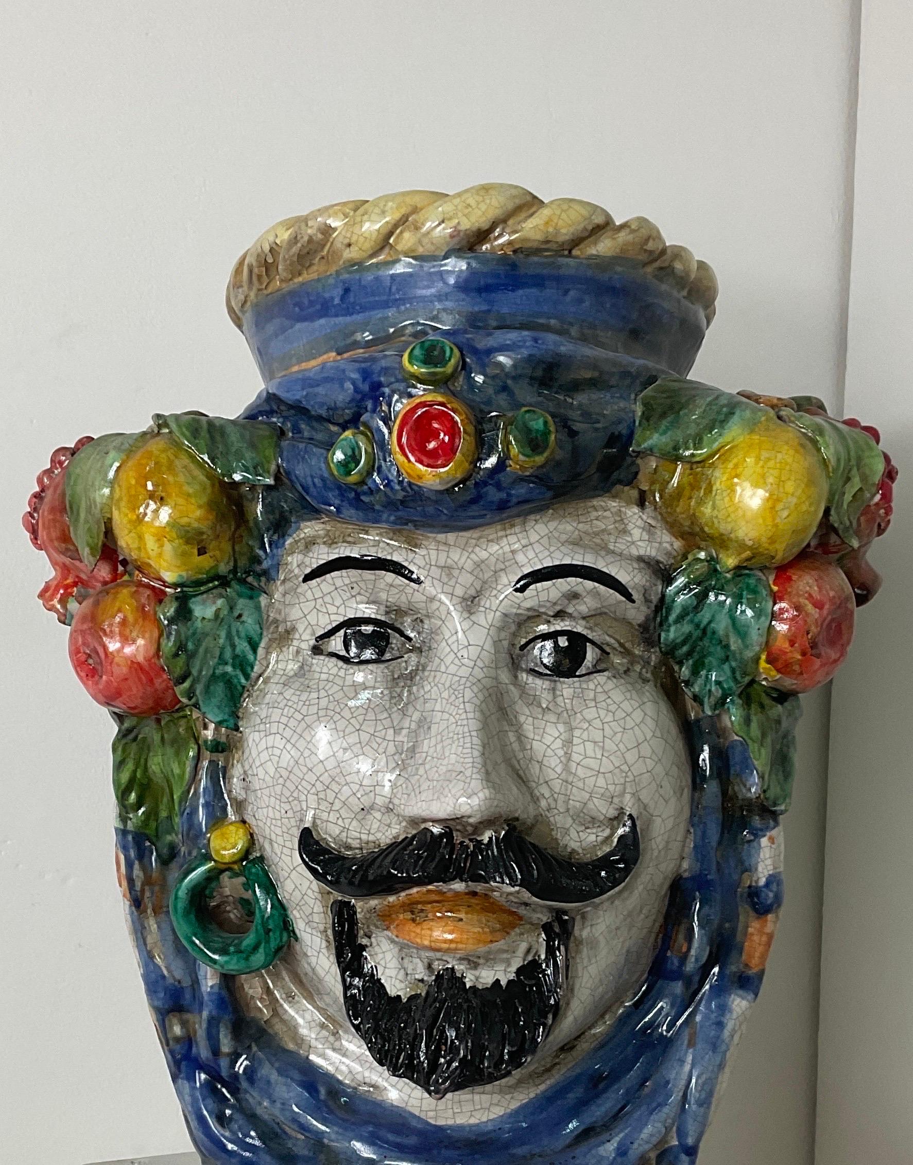 Ceramic coloured Caltagirone head. It is a double-sided bust with a male face and a female face with which we are presented with a liveliness of the two characters through colour. In good condition with wear and tear caused by the passage of time