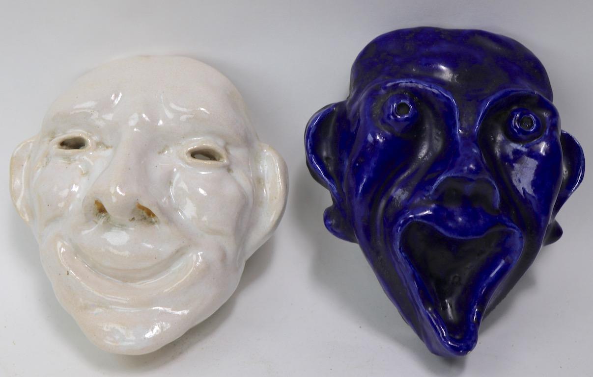 Whimsical handmade pottery Comedy and Tragedy wall mount masks, in deep cobalt blue and creamy off white glaze. Probably studio made circa 1960/1970's both are well done and in very good condition. Blue Tragedy mask 7.25 H x 6.25 W x 3 deep Off