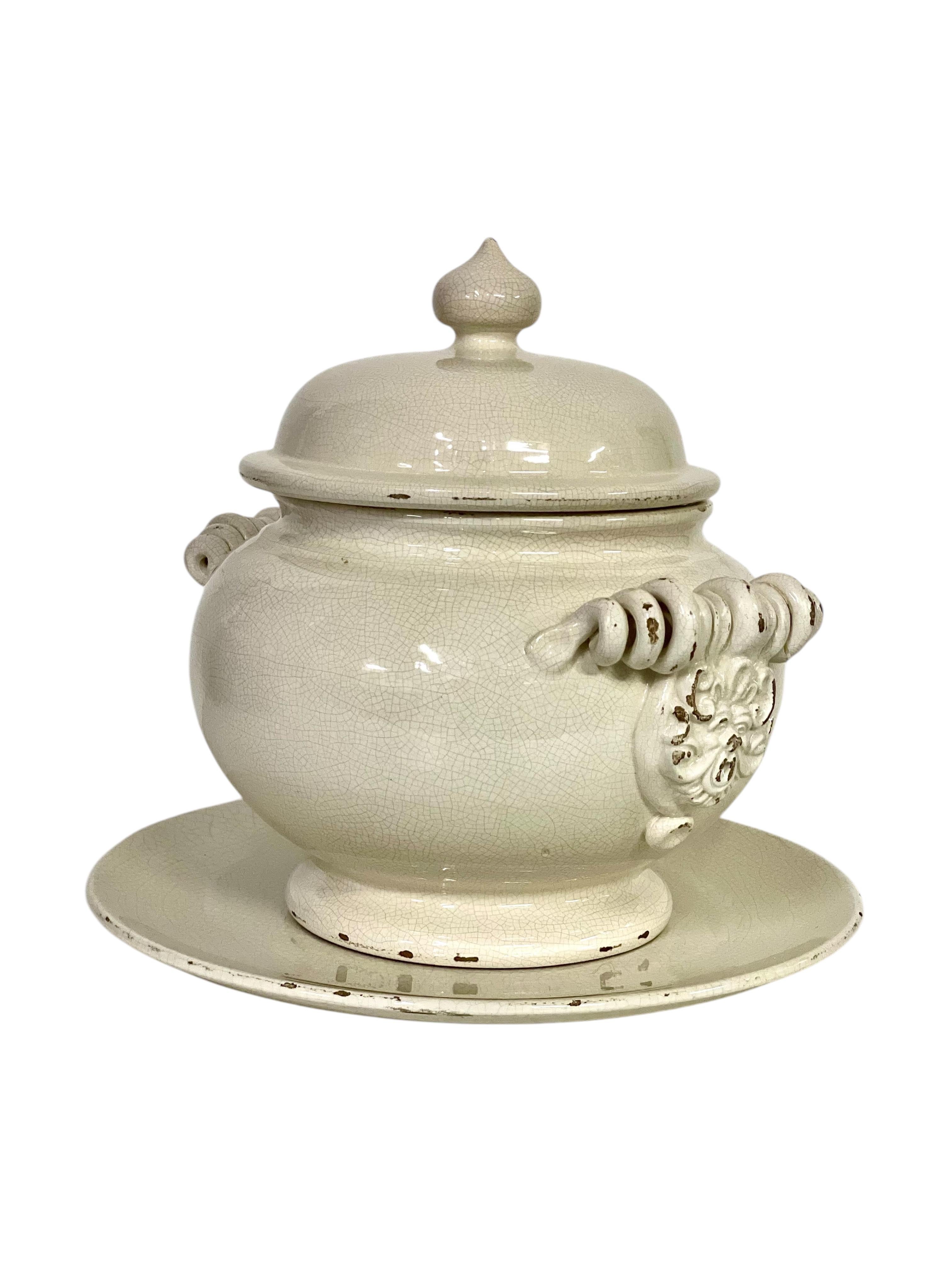 Ajoutez une touche de charme français intemporel à votre table avec cette exquise soupière ancienne et son sous-plat assorti. Fabriquée en céramique émaillée avec une riche glaçure craquelée de couleur crème, cette pièce élégante présente des