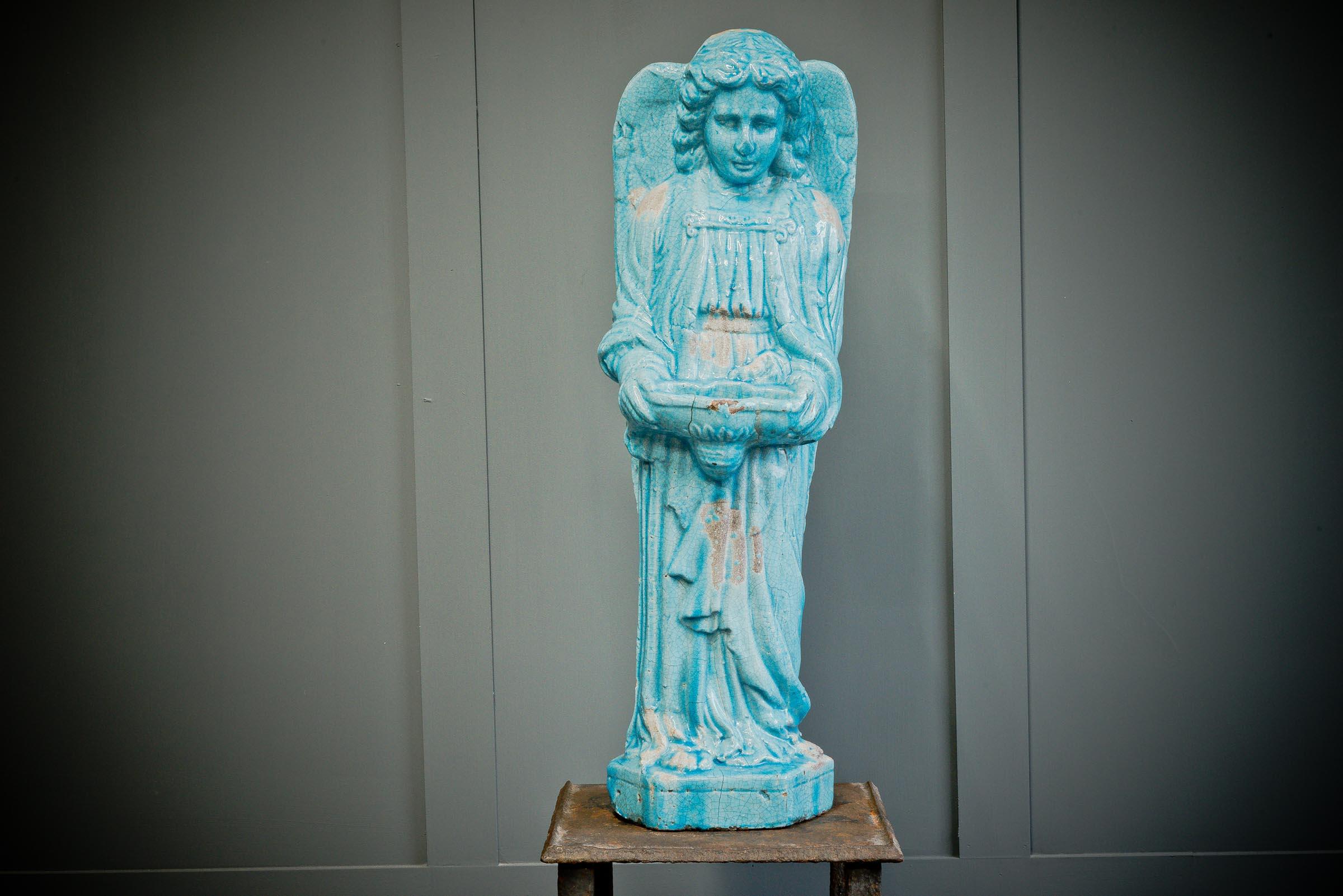 A beautiful striking religious item made from ceramic depicting an angel with over sized wings encompassing the whole piece This holy water font is covered in a blue glaze on top of ceramic to give it a wonderful crackle effect with natural