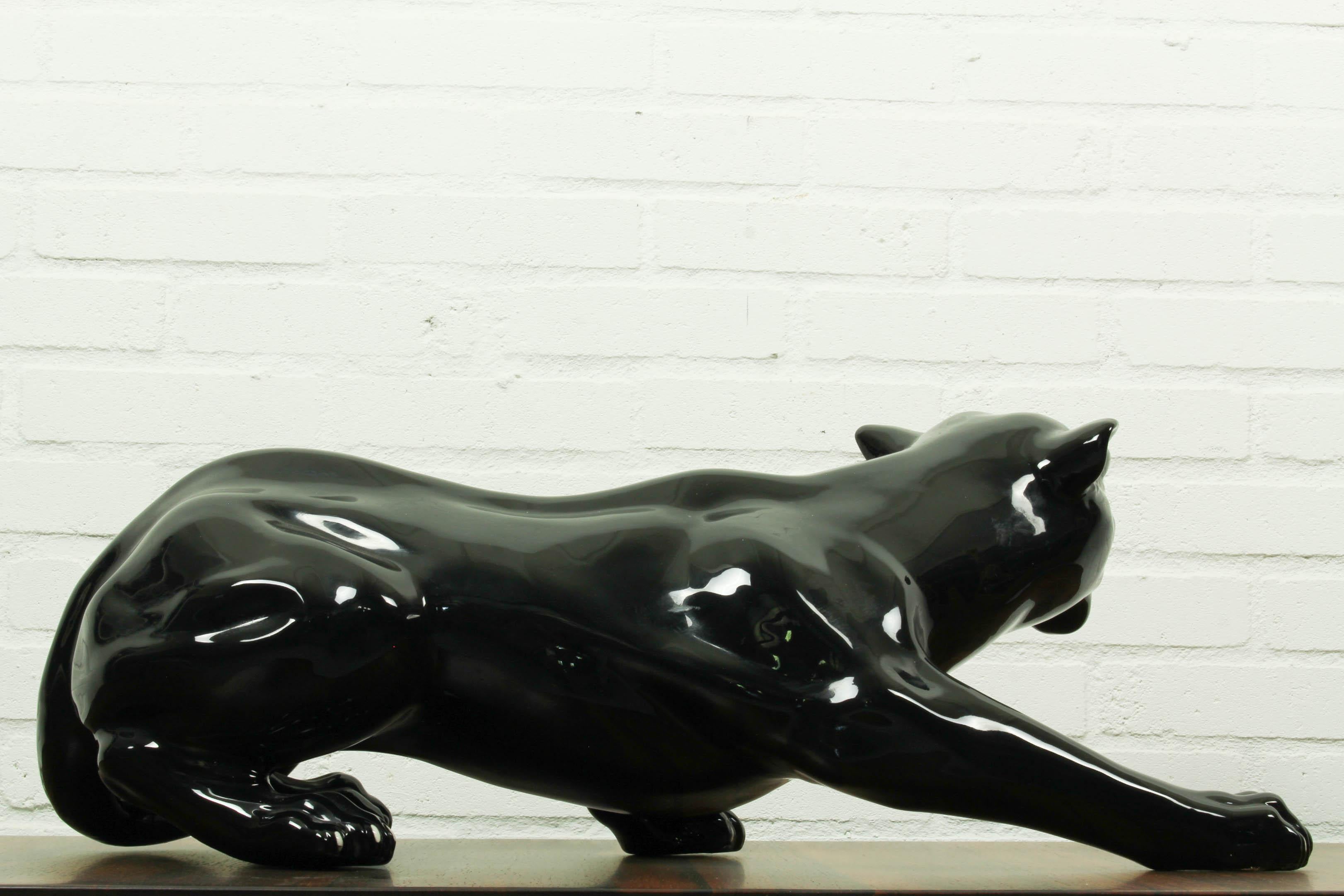 Black ceramic panther, 1970s. This creeping black leopard has fury eyes and is a real black beauty! A fantastic object in your living room as it brings great elegance in an eclectic or Hollywood Regency style interior. 

Measurements: 26cm H, 68cm