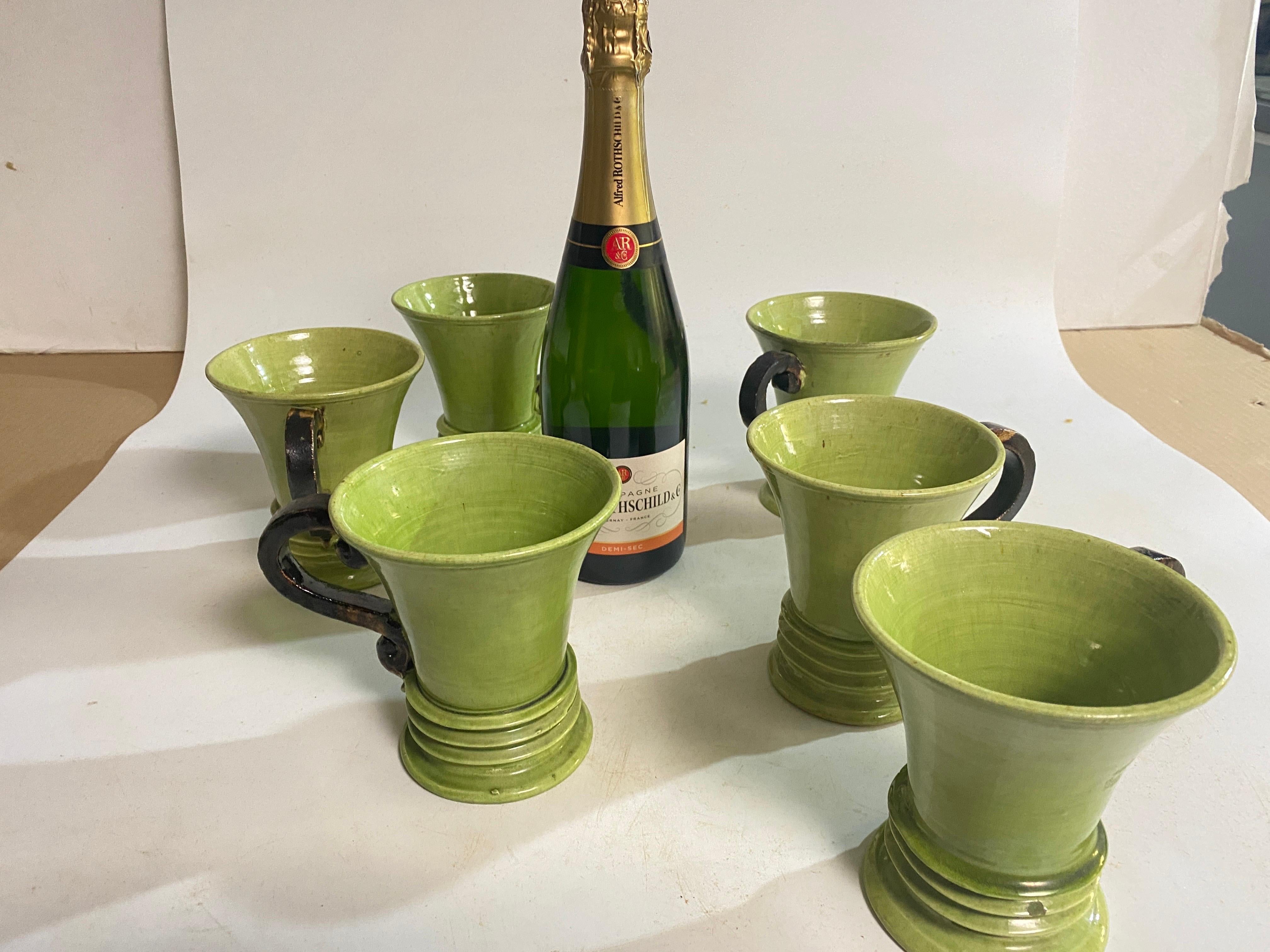 Set of 6 Ceramic Cups, Handmade in France Circa 1970.
The handles of the cup are in a brown Color and the cups are in a  Green Color.