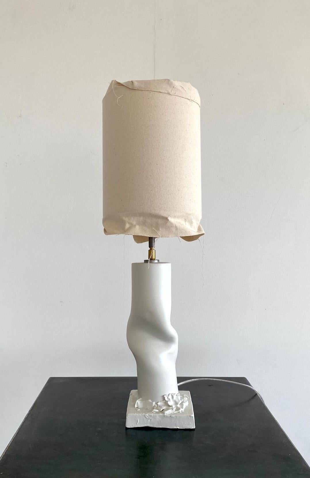 The 'Asiago 01' is a handmade ceramic lamp and part of a project entitled Break the Mold by artist Jenna Basso Pietrobon. 

Adjustable canvas lampshade. Metal and brass details. Lamp is signed on the back or bottom. 

Other voltage/ wiring upon
