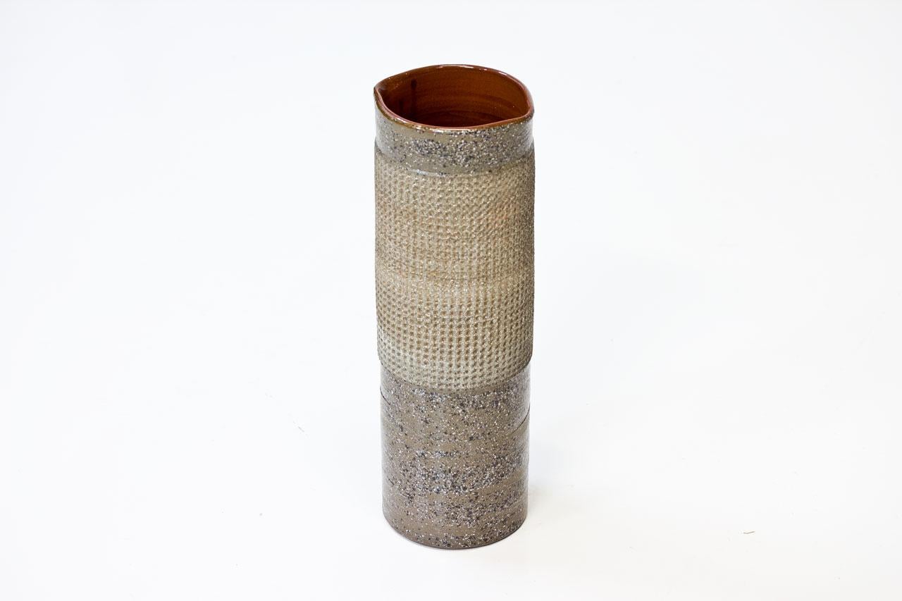 Tall cylinder stoneware vase, designed by Thomas Hellström for Nittsjö in Sweden during the 1960s. Rough expression with monogram. Signed on the bottom.