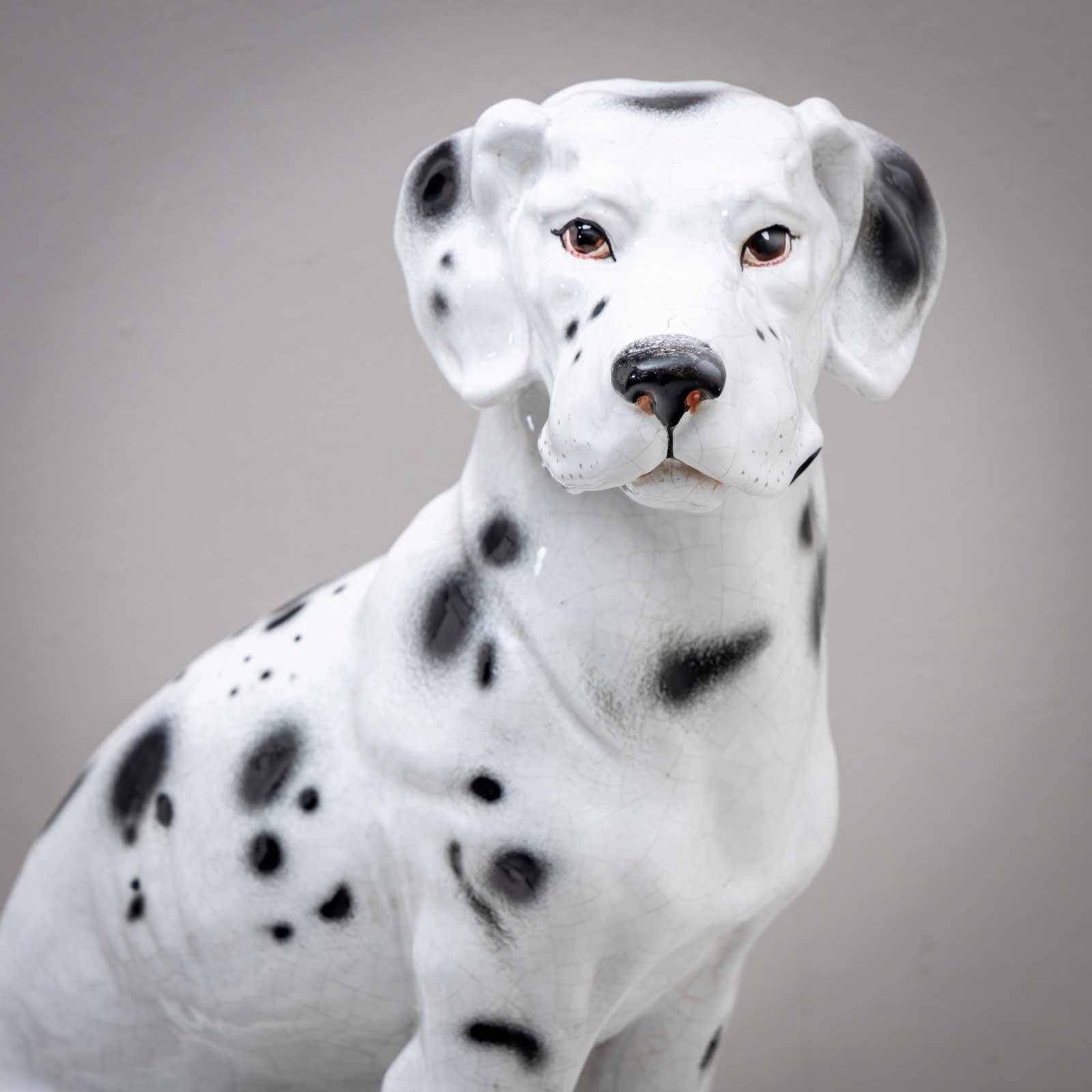 Large, naturalistically designed ceramic figurine of a seated Dalmatian. The glaze has a slight craquelure. Stamped Made in Italy on the base.