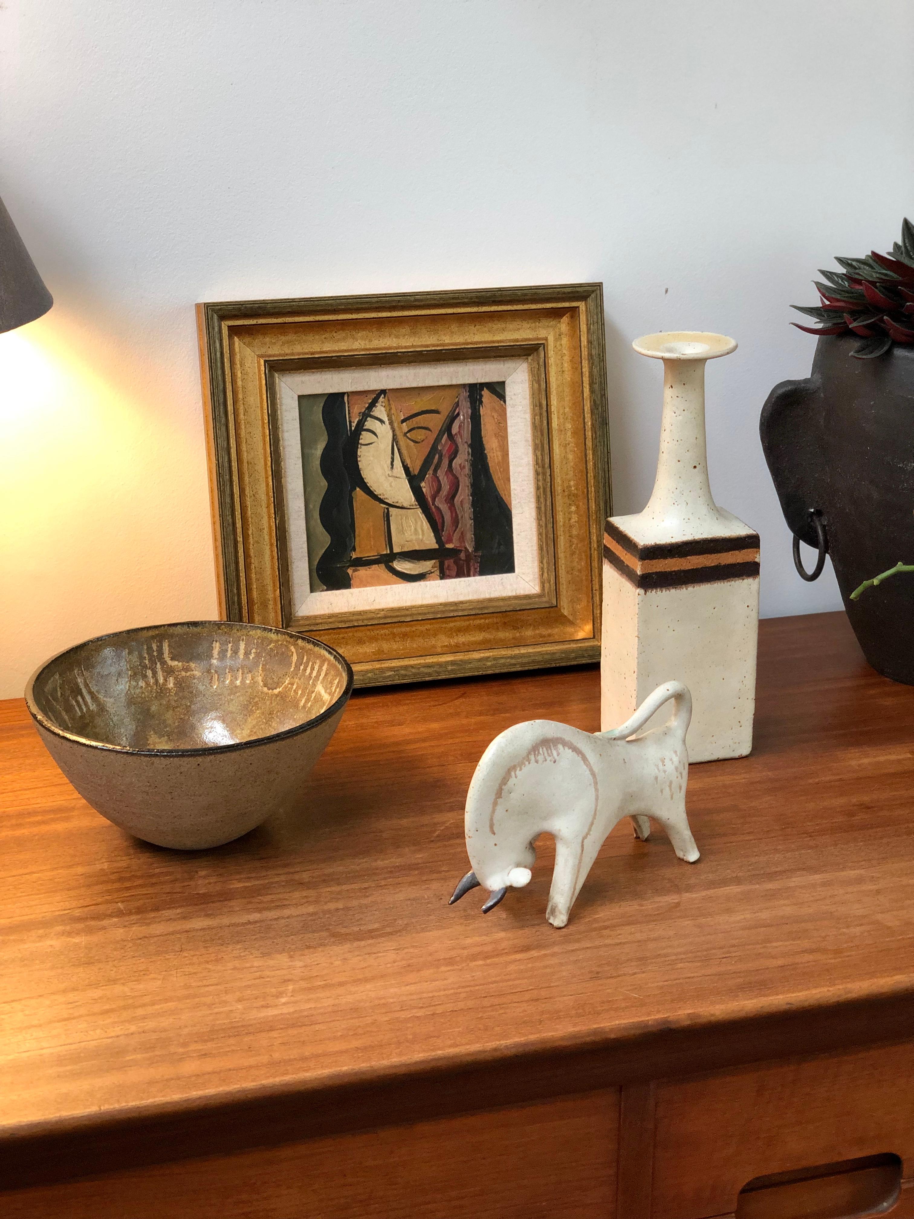 Ceramic decorative bull by Bruno Gambone, circa 1970s. This is a piece from Gambone's series of chalk-white ceramic animal sculptures. A charging bull with brown lines outlining the front torso; one of the lines have drip markings from the painting