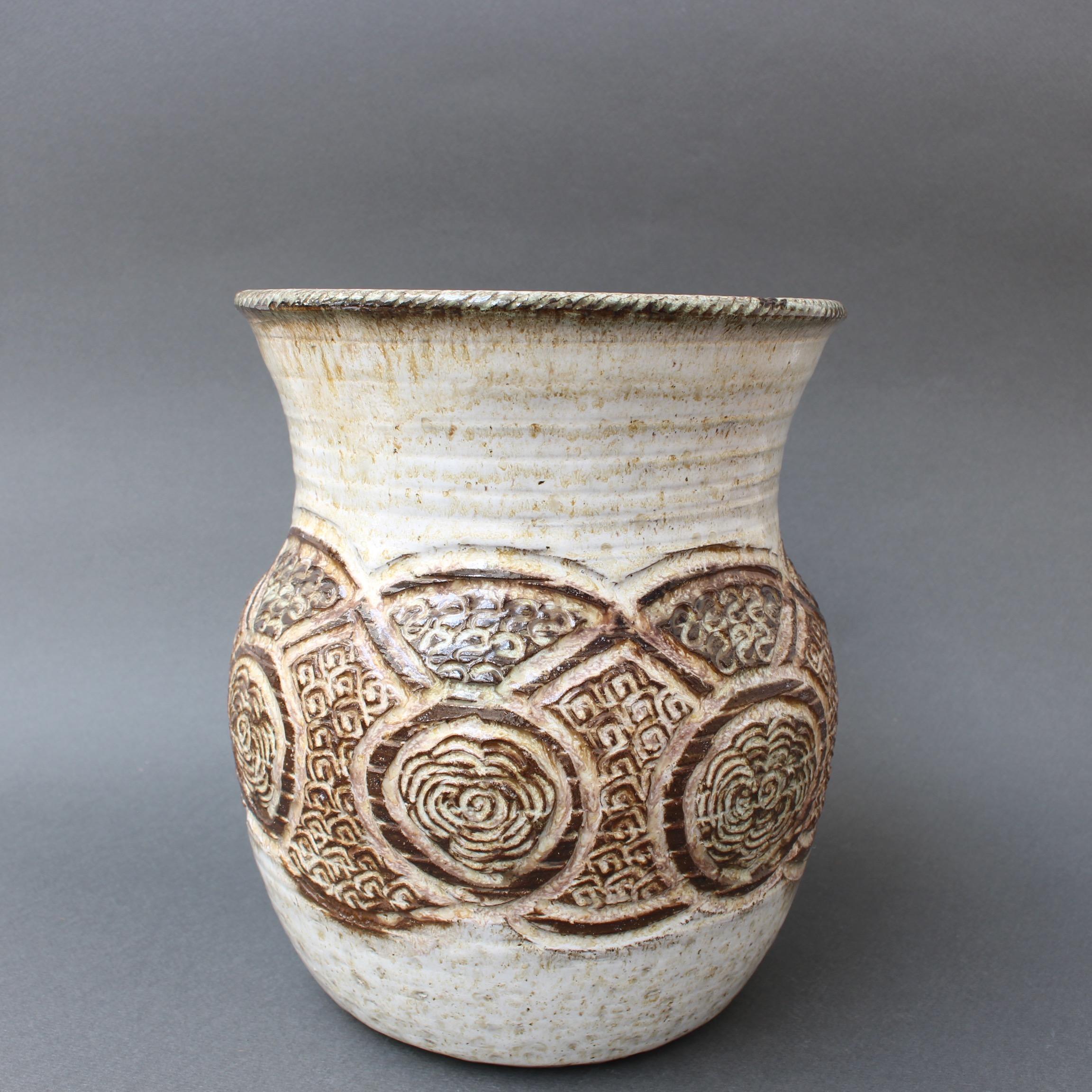 Midcentury ceramic glazed vase (circa 1960s) by Marcel Giraud, Vallauris, France. A piece with a graceful, curvy shape, wide mouth and muted chalk-coloured base, it is the epitome of vintage 20th century style. This stunning vase has a tribal floral