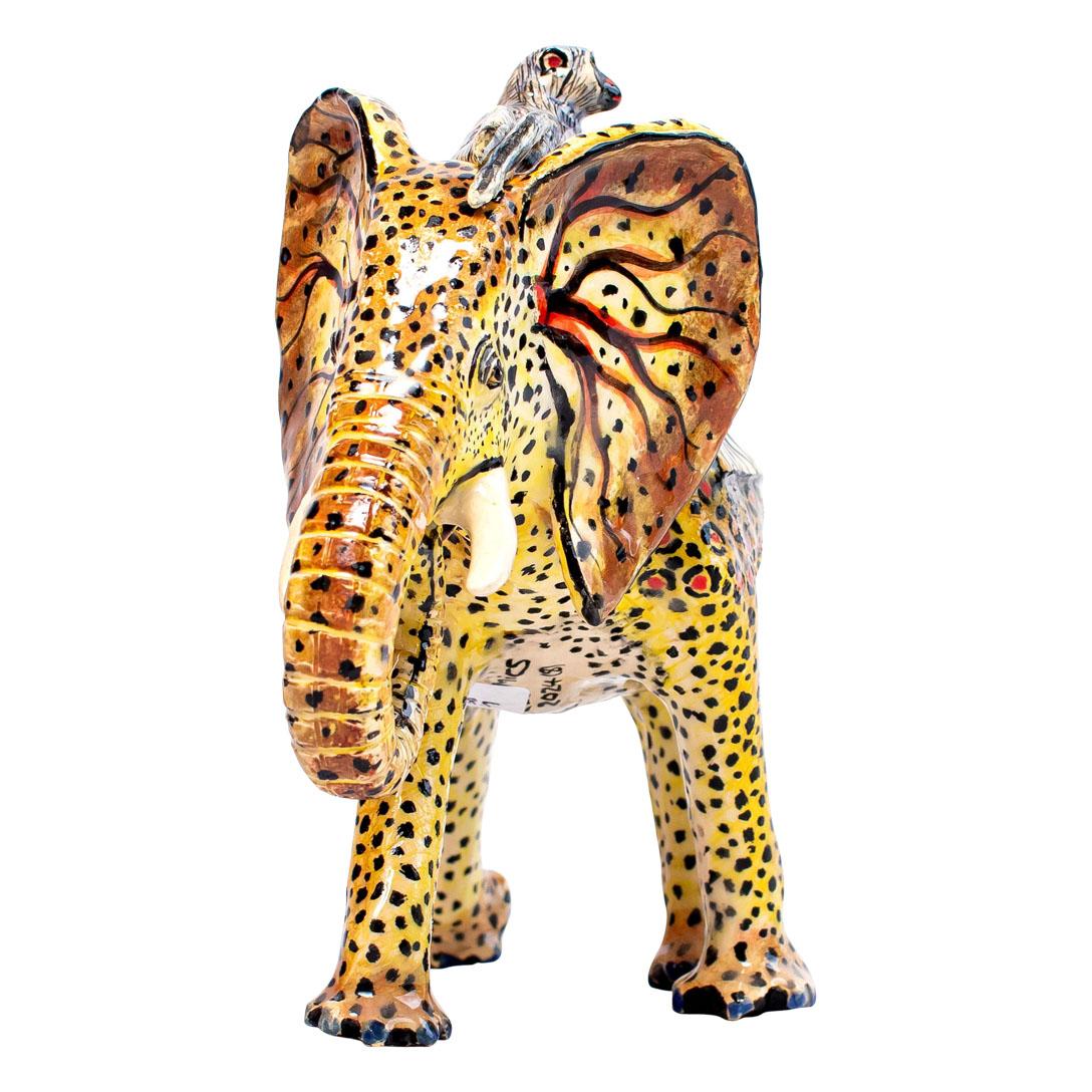 The Royal Elephant with Leopard Skin, crafted by Zimele Ceramics in South Africa, is a stunning ceramic sculpture that stands 8 high and measures 8 in both length and width. This exquisite piece is hand-painted by Sello and hand-sculpted by Sneh,