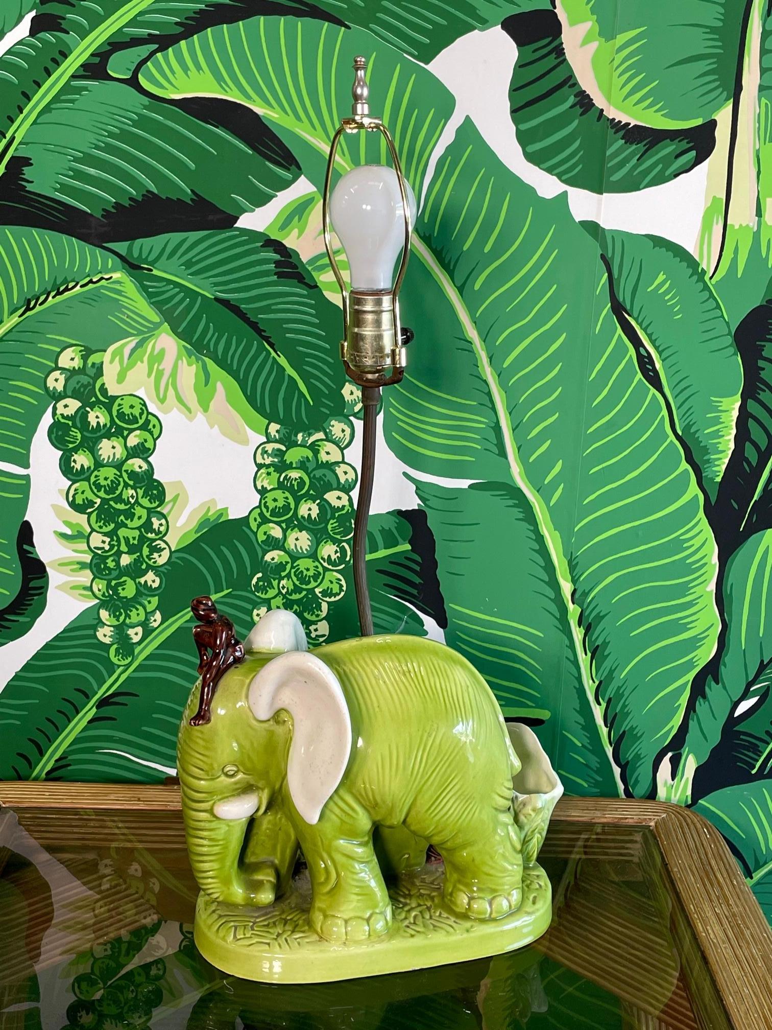 Cette lampe de table vintage en céramique à l'effigie d'un éléphant comporte un bac à plantes et un mignon personnage monté sur sa tête. Bon état vintage avec des imperfections correspondant à l'âge (voir photos). La face arrière montre une