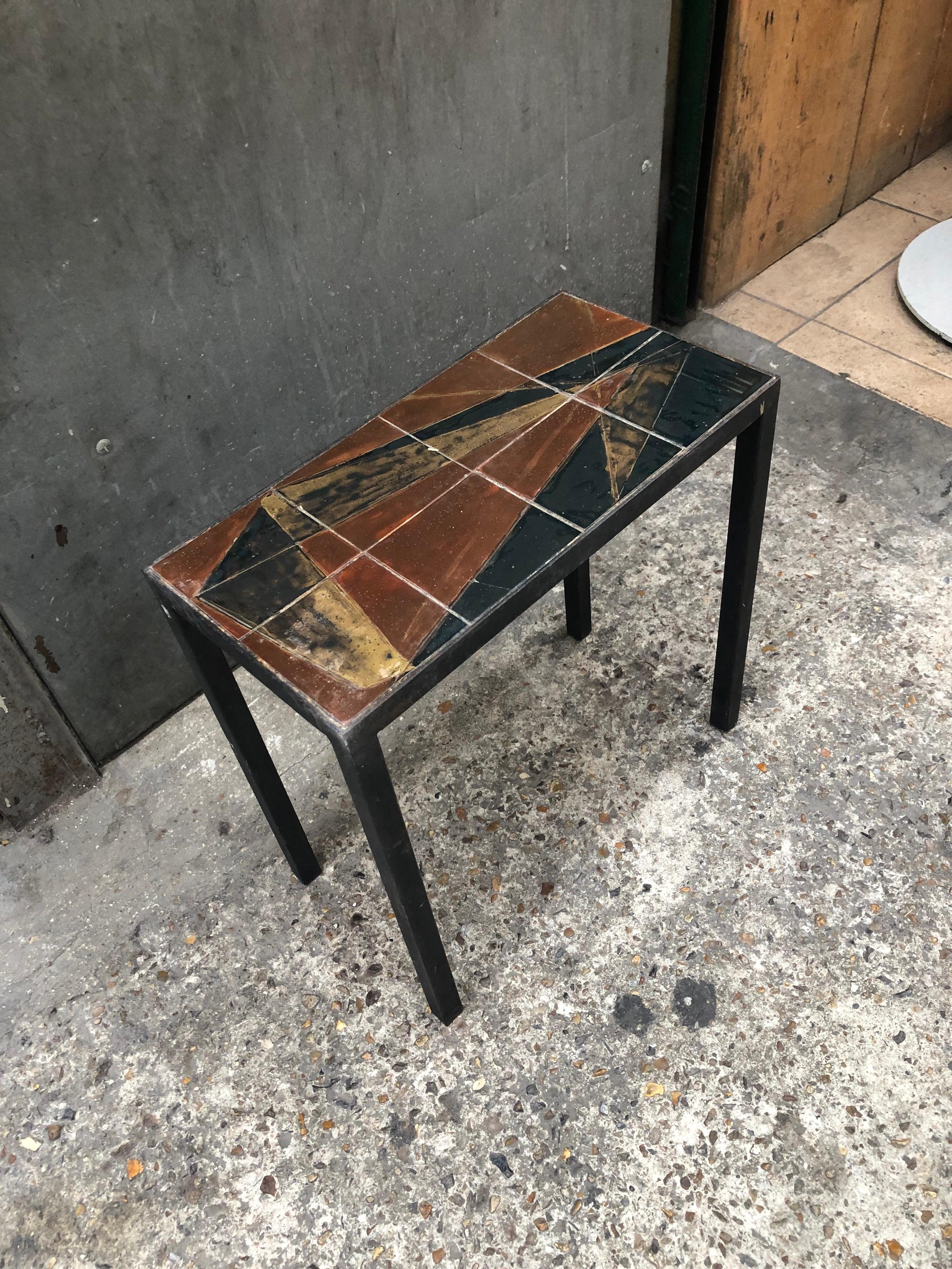 An exquisite end table, circa 1960 in ceramic and base in black lacquered steel
the ceramic is in very good shape black and gold are dominated the cubist design
no signature on the ceramic but a little mark can be seen.