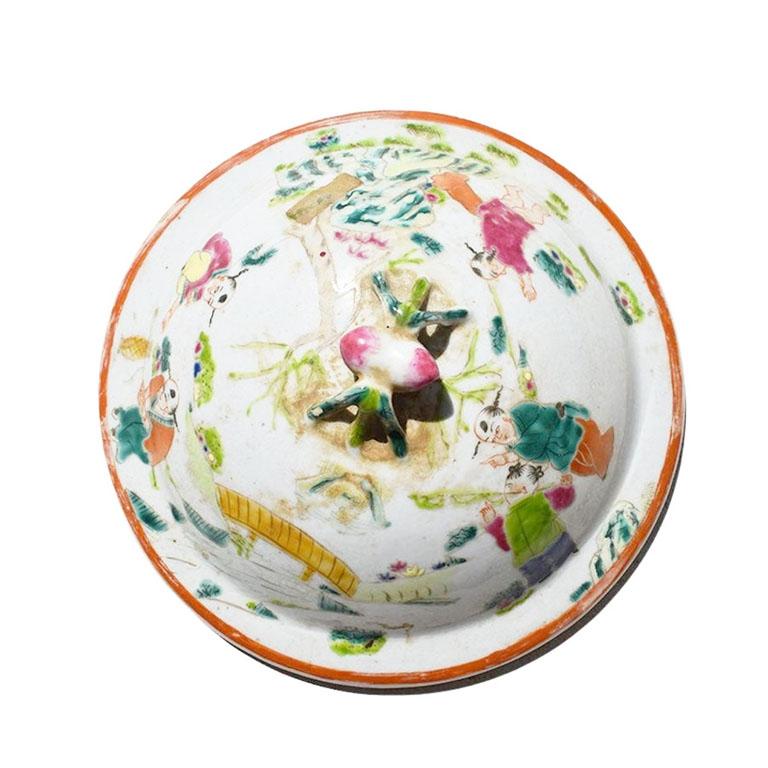 A round ceramic famille rose bottle or urn lid. Although the base of this piece is missing, we love the idea of hanging it on a wall as a decorative chinoiserie wall decoration. The top has a small handle in the shape of a bug. Around the edges, are