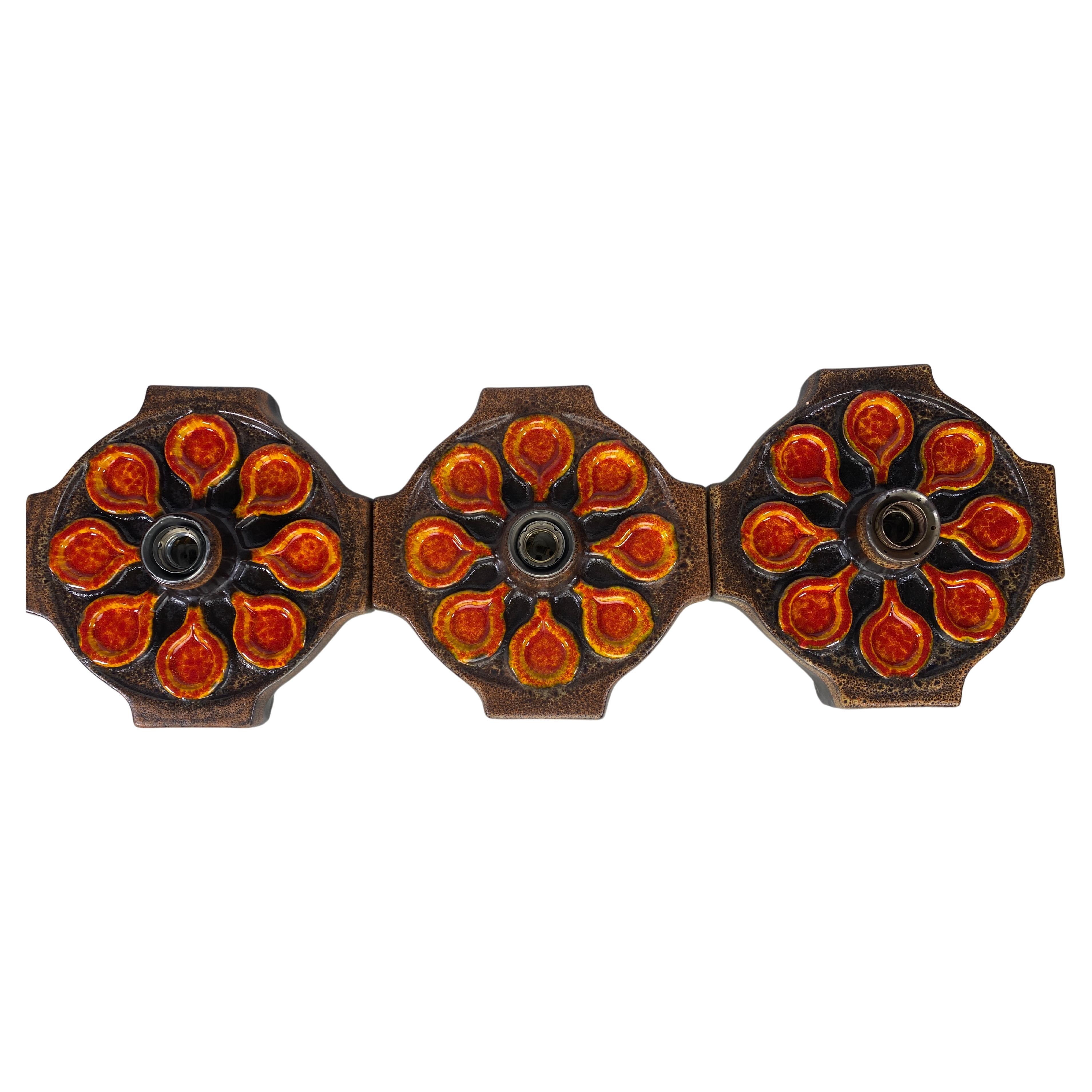 Characteristic Fat Lava ceramic wall lamps. Beautiful different tones of brown and orange colored glazed ceramic. This set of 3 wall-lamps can be styled in many different ways in your interior. They give a warm look and feel. 

The patterns on the