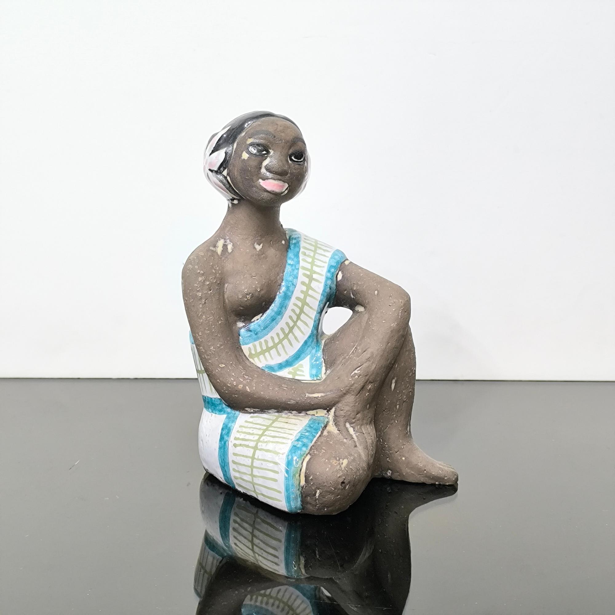 Figurina in ceramica, Upsala Ekeby, Svezia, 1960 ca.
Quest'opera scultorea di Mari Simmulson in  La ceramica smaltata cattura una donna tahitiana seduta in un momento di tranquillo equilibrio. Realizzata in ceramica smaltata con un abito monospalla