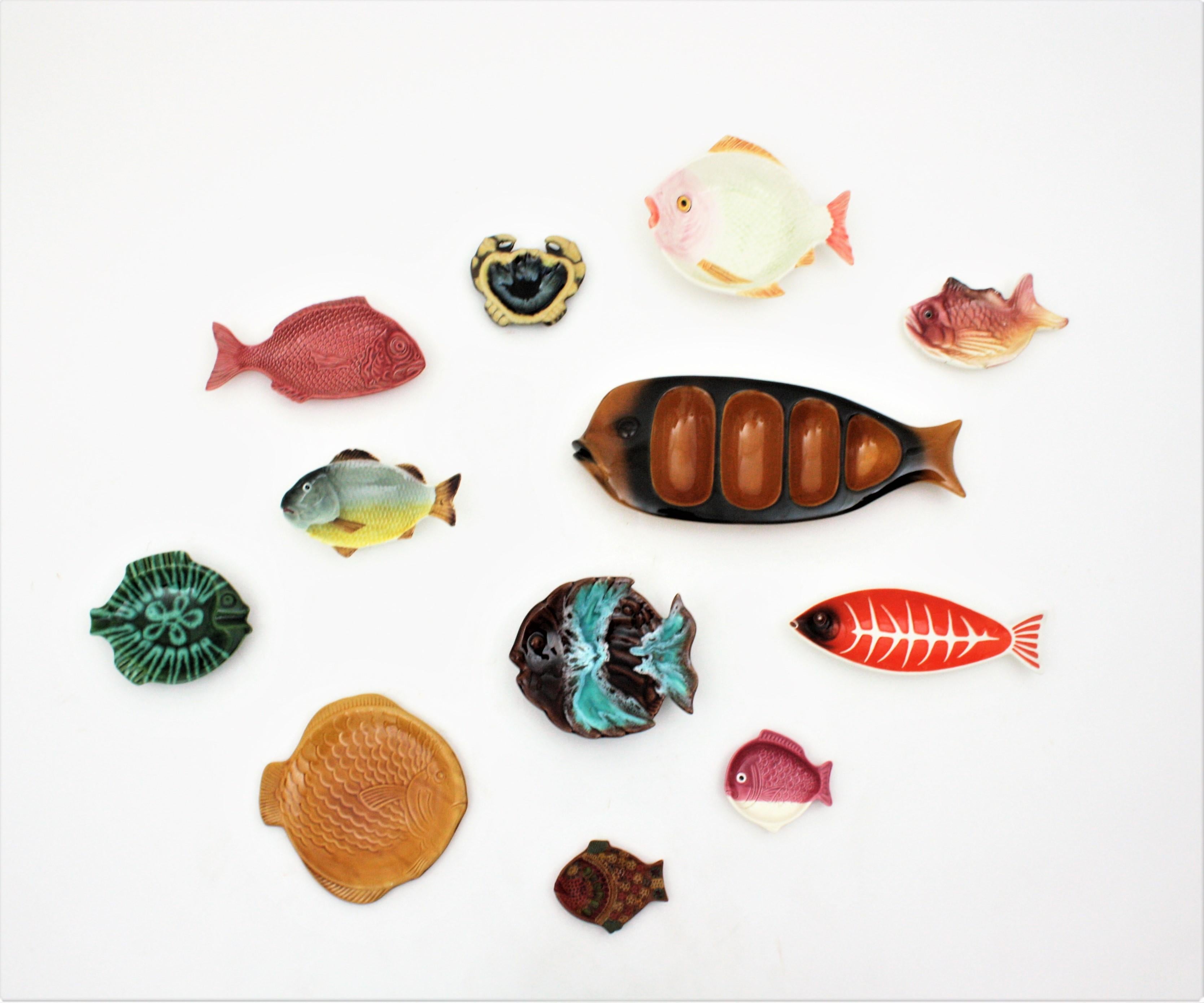 Satz mehrfarbiger Fischteller und -platten aus der Mitte des Jahrhunderts als Wanddekoration
Eine lustige Sammlung von zwölf europäischen Fischen aus glasierter Keramik, Porzellan und Terrakotta in verschiedenen Formen und Größen.
Sie stammen aus