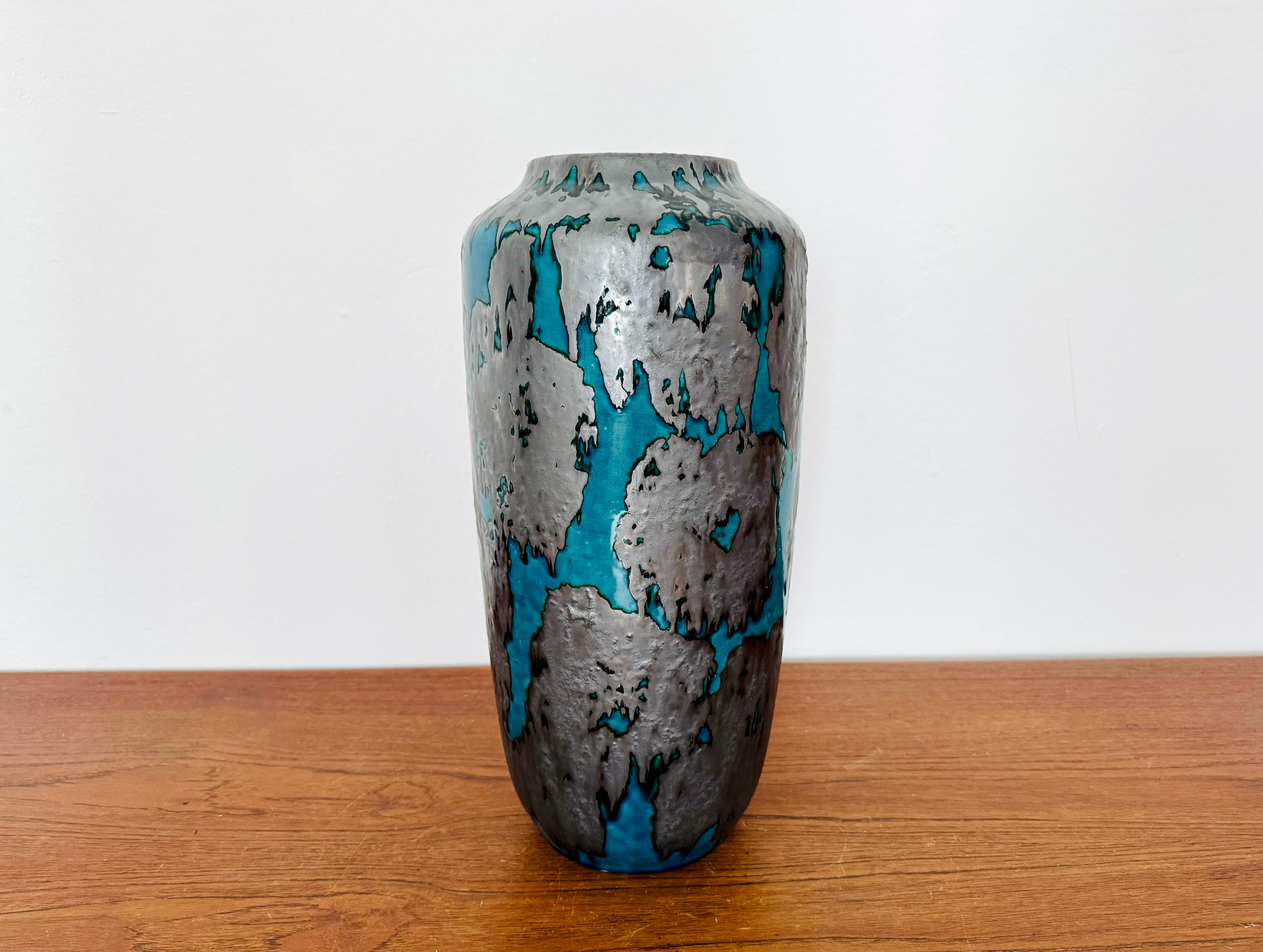 Très beau et inhabituel vase de sol en céramique des années 1960.
La combinaison des couleurs avec la glaçure bleu-vert et argent-noir est particulièrement réussie.
Un design magnifique et un objet en céramique spécial pour les