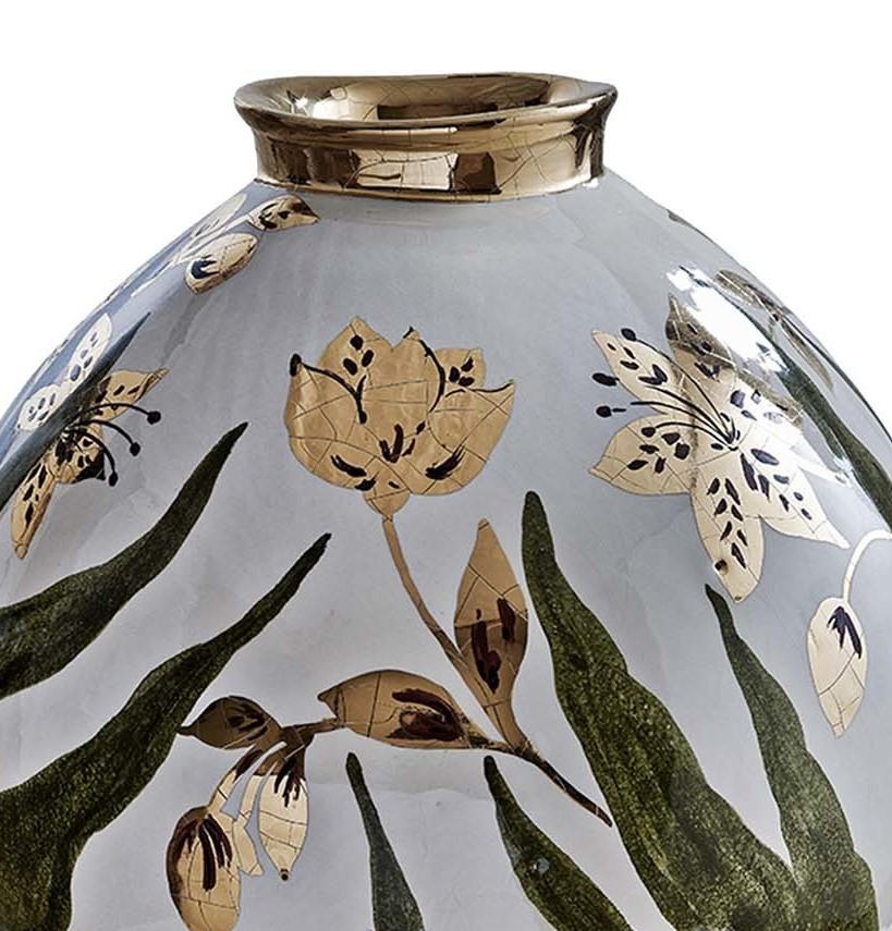 Stunning in its simplicity, this ceramic vase will add a lovely accent to any modern or antique decor. Whimsical flowers in lavish gold-coin finish adorn the surface, accented by bold green leaves on a light blue background. The graceful Silhouette