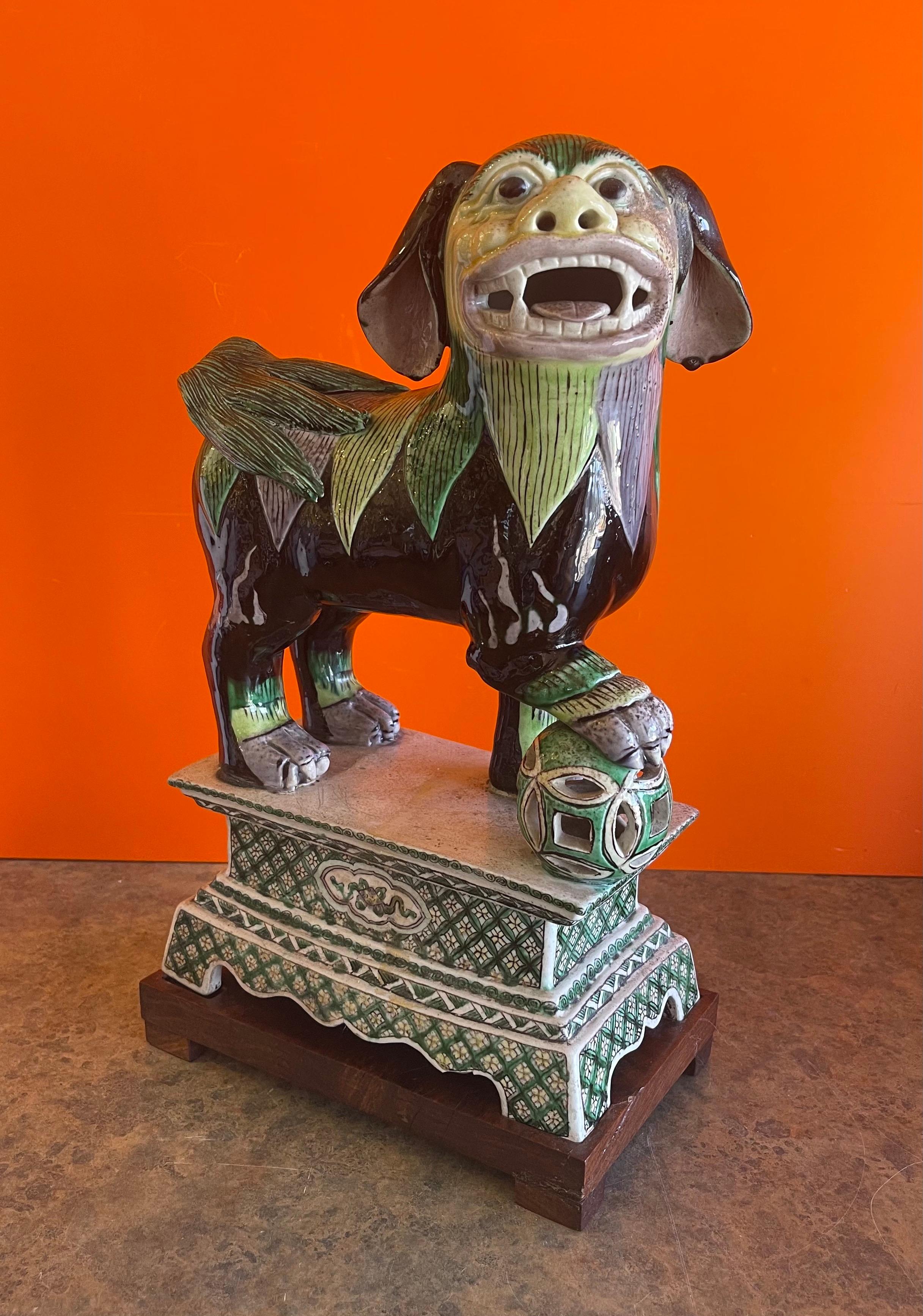 A very nice ceramic foo dog sculpture on mahogany base, circa 1980s. The piece is hand painted and has great detail. It is in very good vintage condition and measures: 9