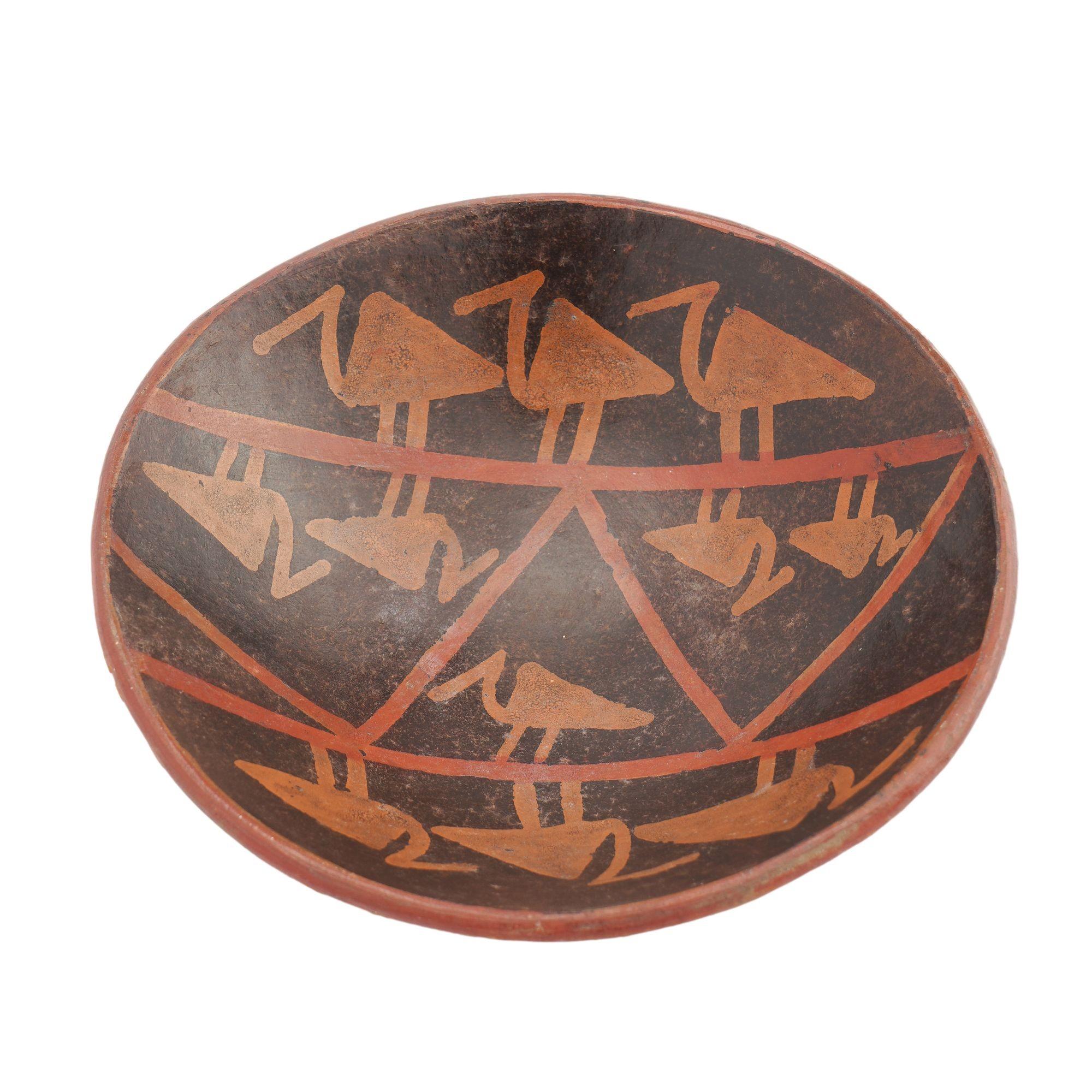 Bol en poterie d'argile rouge, à pied peu profond, tourné à la main d'après un modèle Pre-Columbian. La coupe est décorée en noir et rouge oxyde de quatre bandes d'oiseaux se reflétant le long de deux lignes parallèles. La face inférieure est
