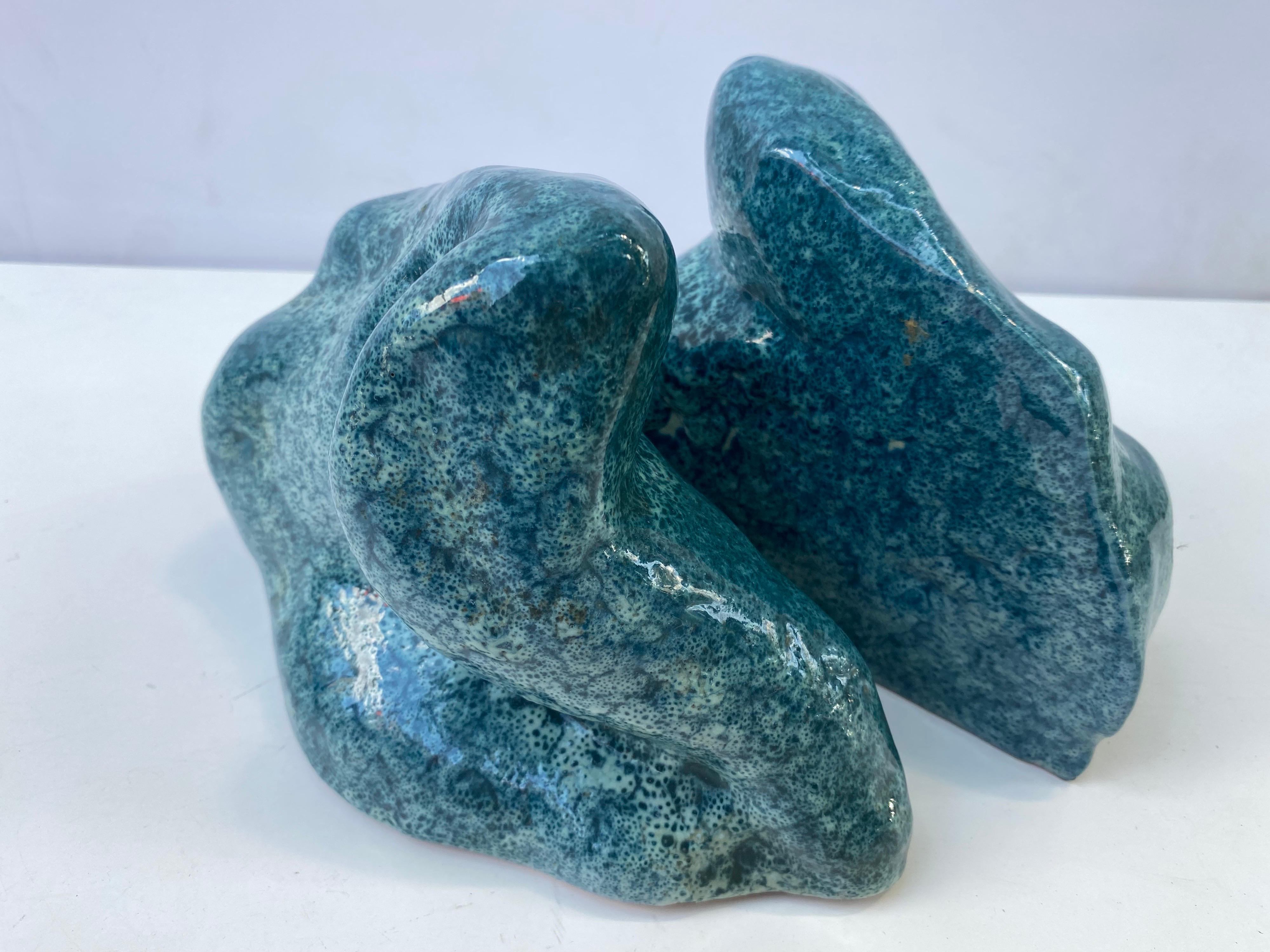 Ceramic free form blue bookends. Weighted bookends with a bluish glaze. Looks like a molten dropped liquid!
