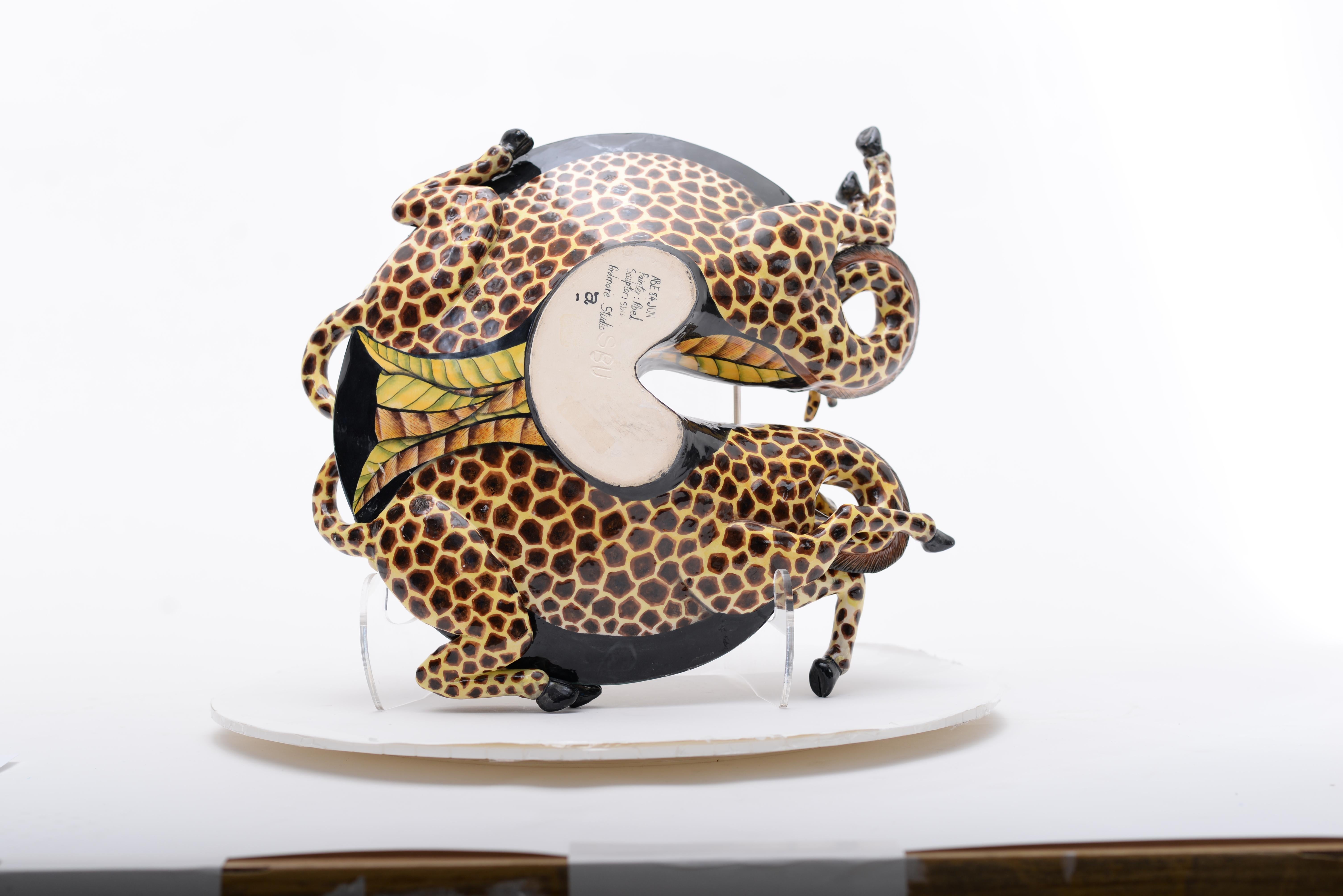 The Giraffe Bowl from Ardmore Ceramics, a masterpiece crafted in South Africa. Standing 7 inches tall, 15 inches long, and 16 inches wide, this ceramic art piece is a testament to the skill of Sbusiso Ndaba and Abel Mohlakoana. Each detail, from the